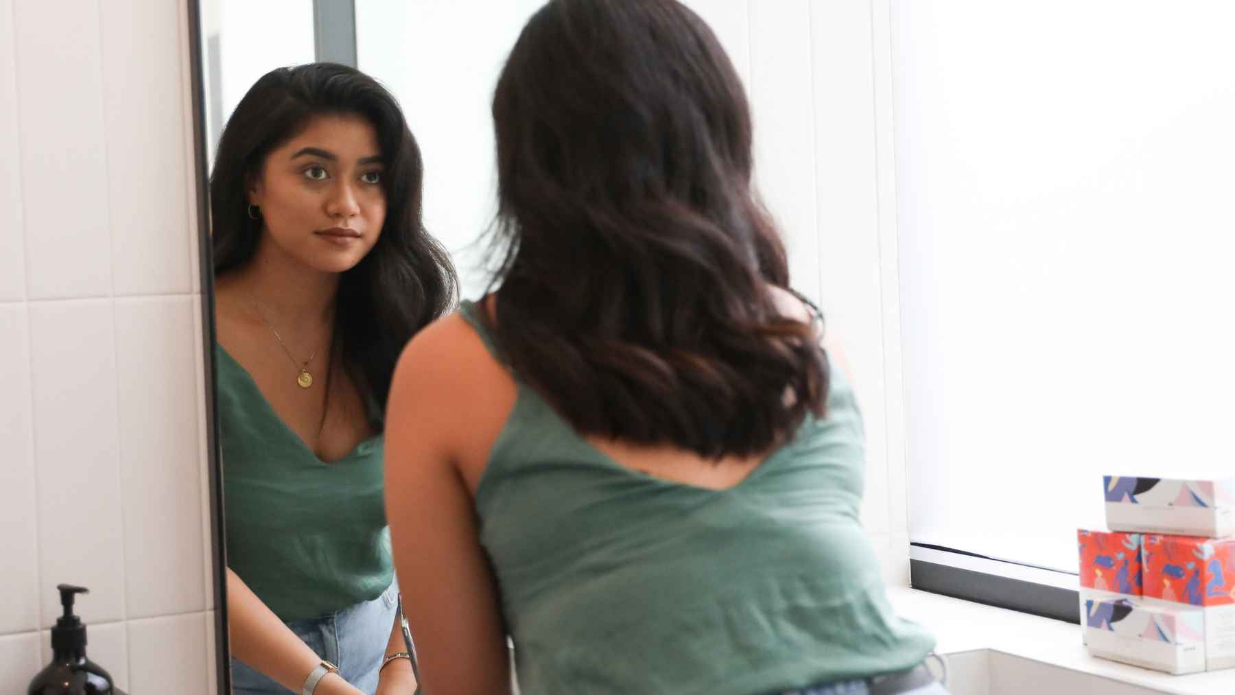 Thoughtful person reflecting alone, illustrating psychology research on childhood praise, self-worth, and internal validation