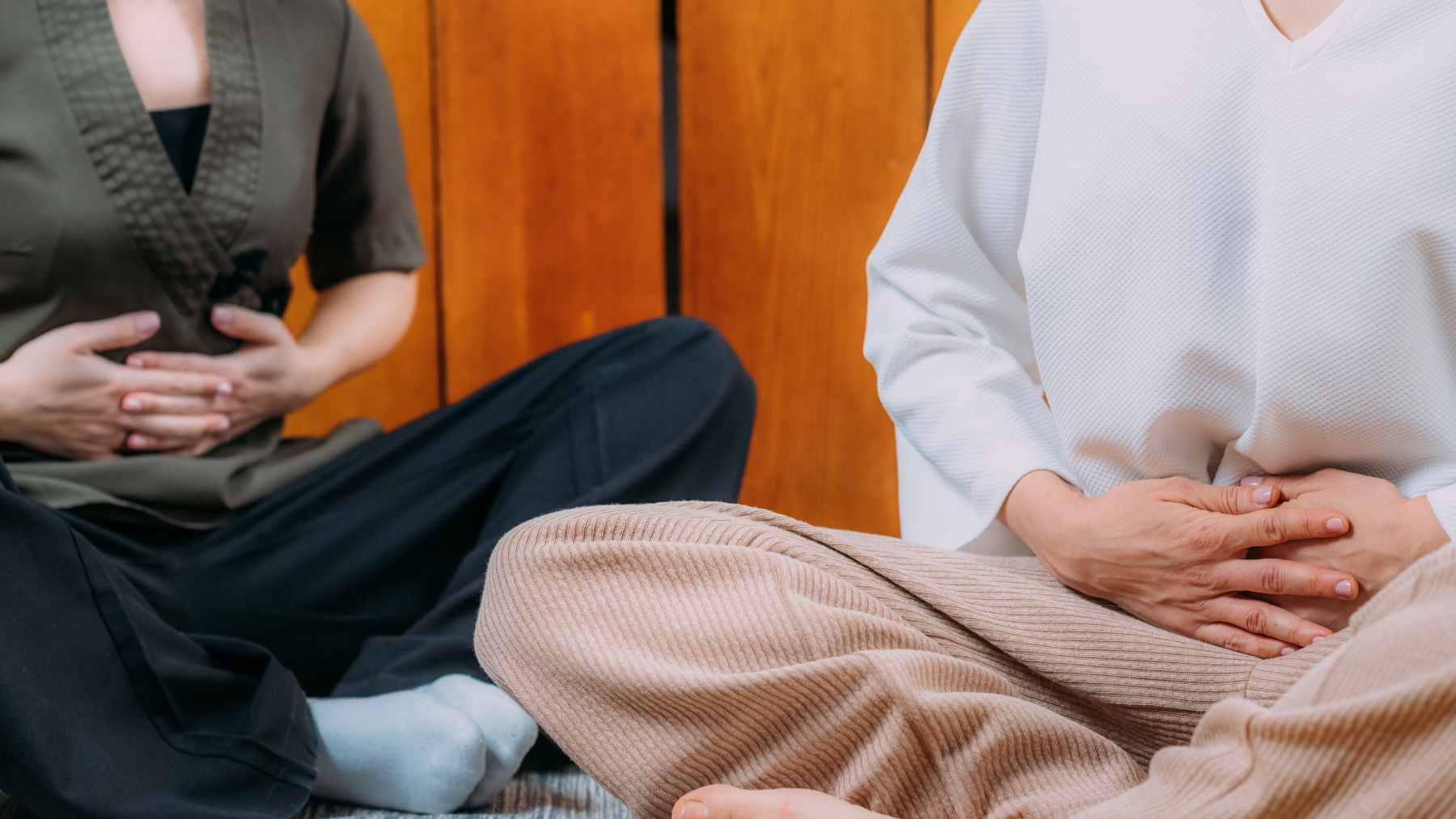 A person practicing diaphragmatic breathing with a hand on their belly to calm anxiety and lower stress.