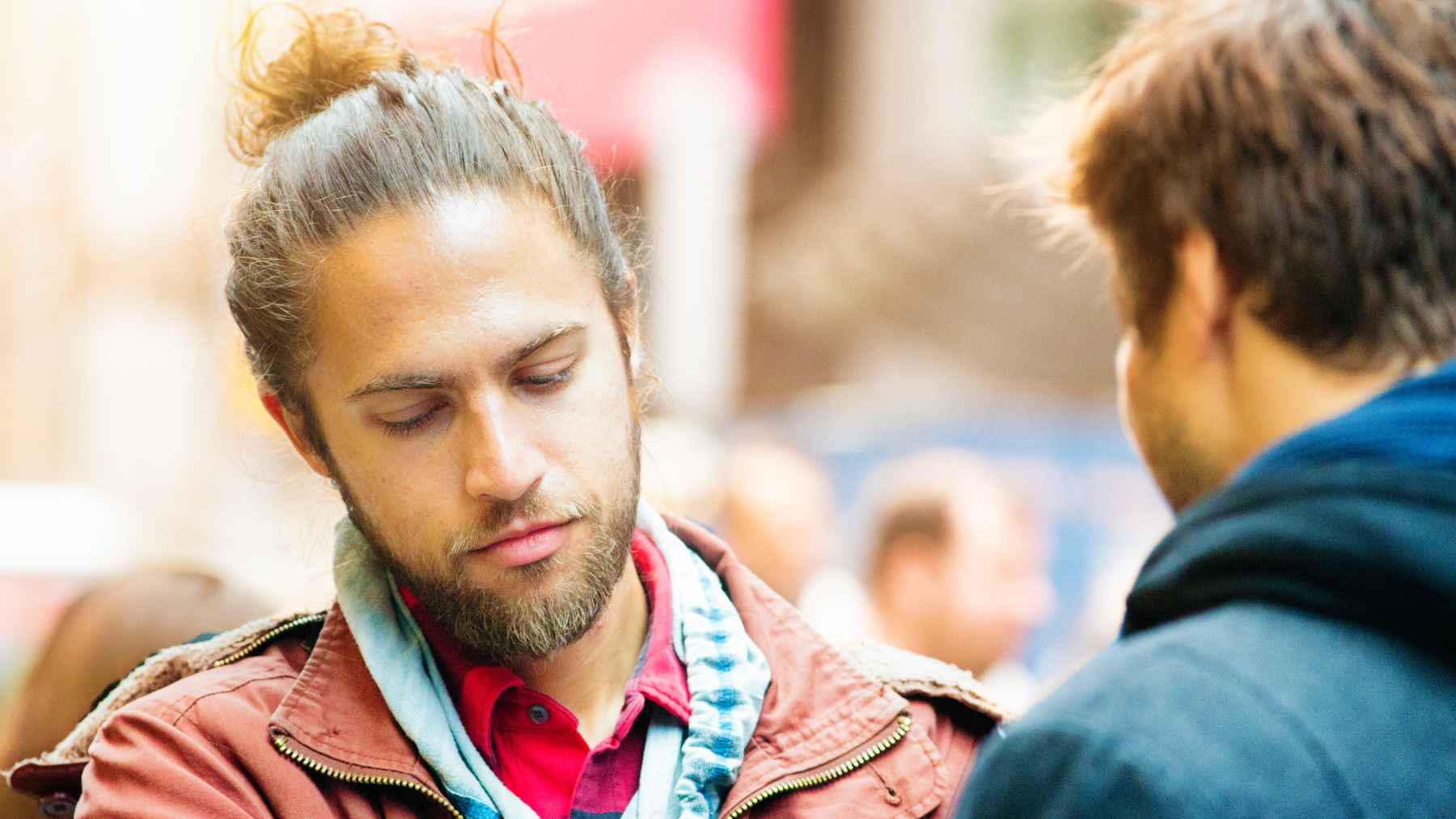 Person avoiding direct eye contact during a conversation, illustrating psychological research on communication and social behavior