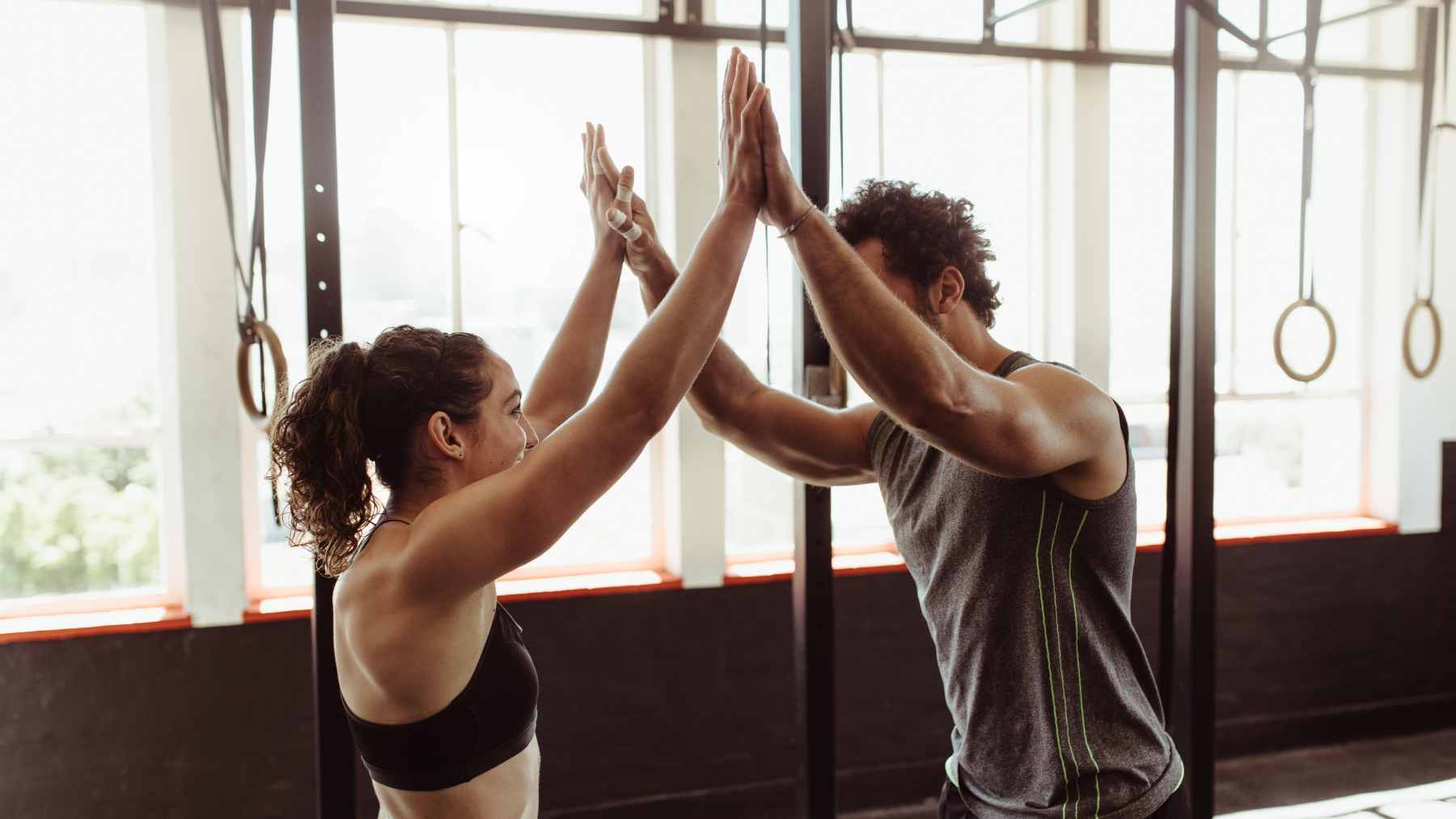 A couple at home preparing for different exercise routines, representing a healthy acceptance of individual fitness preferences.