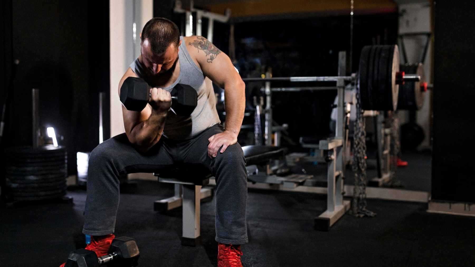 A man in his 40s performing a controlled goblet squat with a dumbbell in a home gym setting.