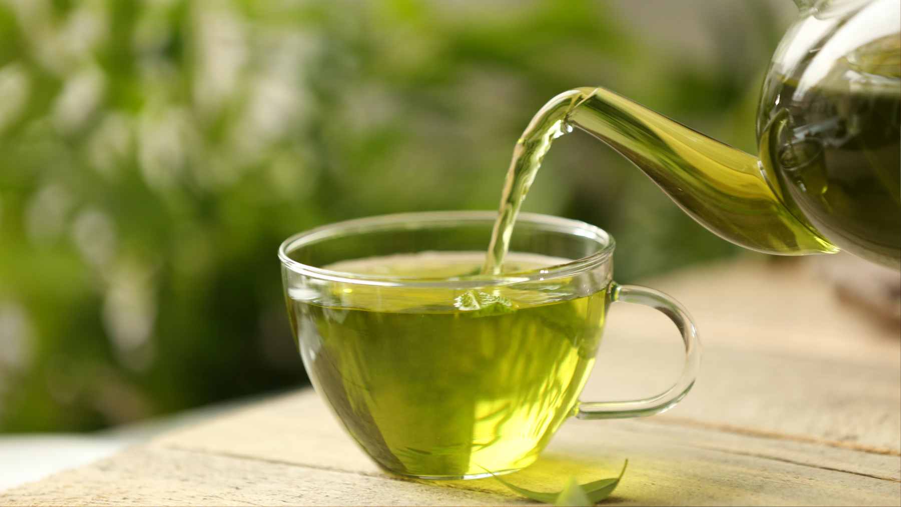 A steaming cup of green tea on a wooden table, symbolizing a heart-healthy daily habit.
