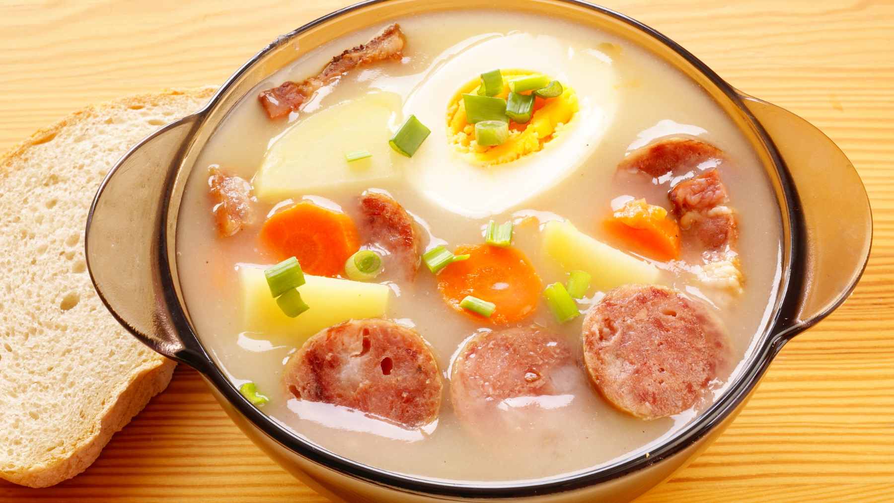 A bowl of Chef Select żurek soup from Lidl featuring white sausage, bacon, and traditional rye base.