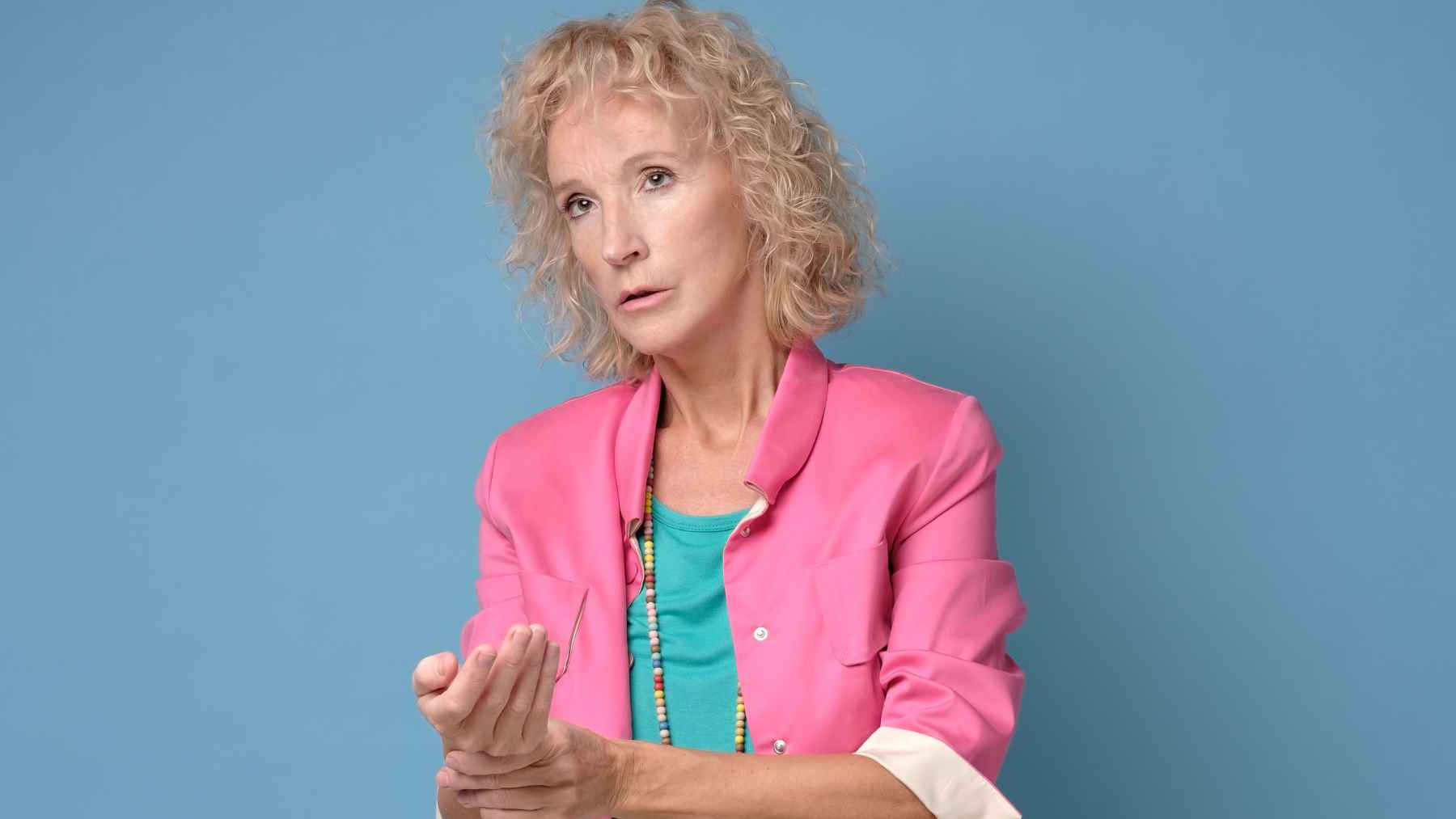 Middle-aged woman experiencing menopause symptoms as doctors warn that persistent palpitations and tachycardia should be evaluated.