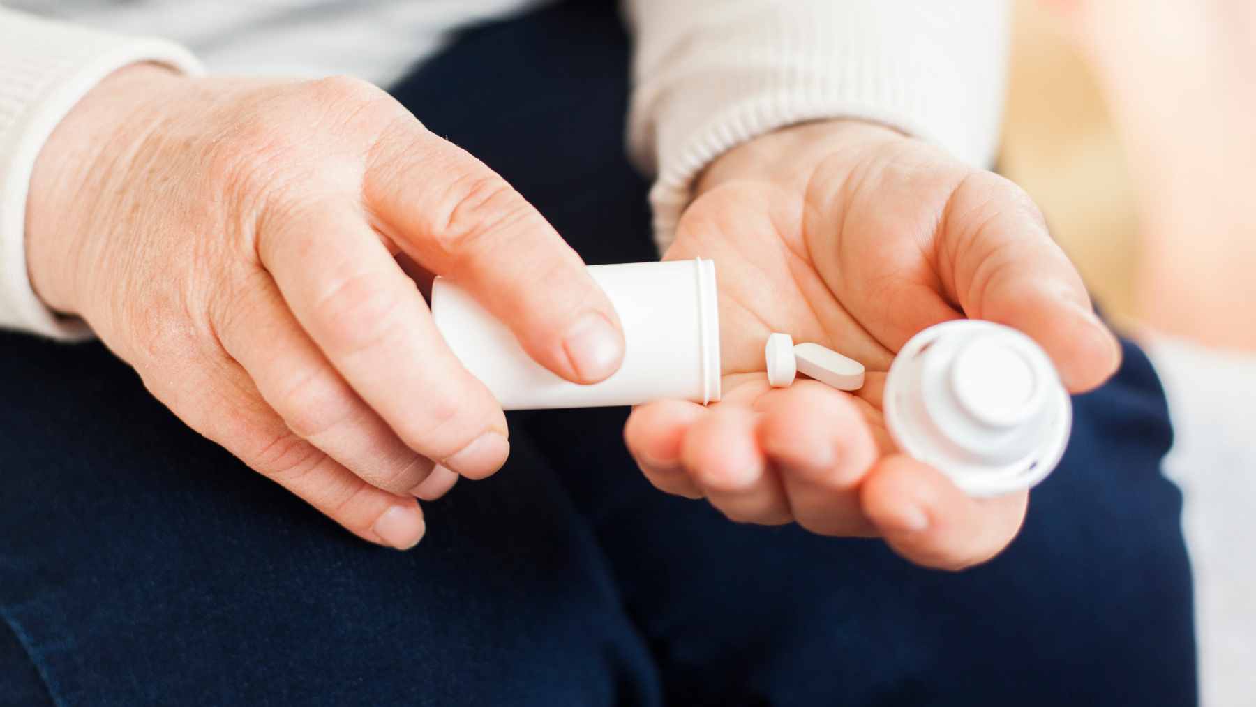 A bottle of prescription liquid naproxen oral suspension sits on a bathroom counter, highlighting the need for patients to check lot codes.