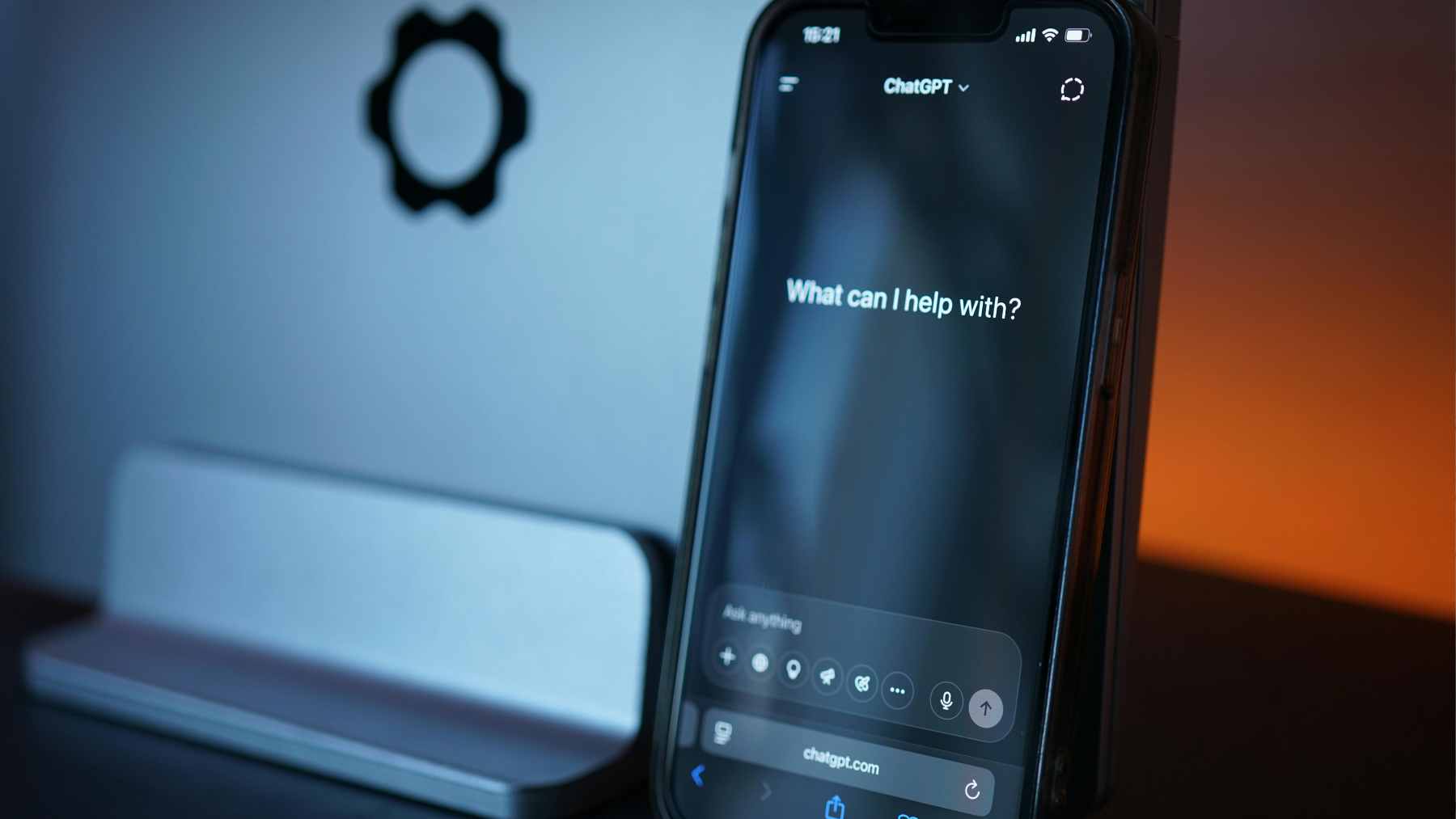 A person sitting in a dimly lit room using a smartphone to communicate with an AI chatbot, symbolizing the emotional risks of long-term digital interactions.