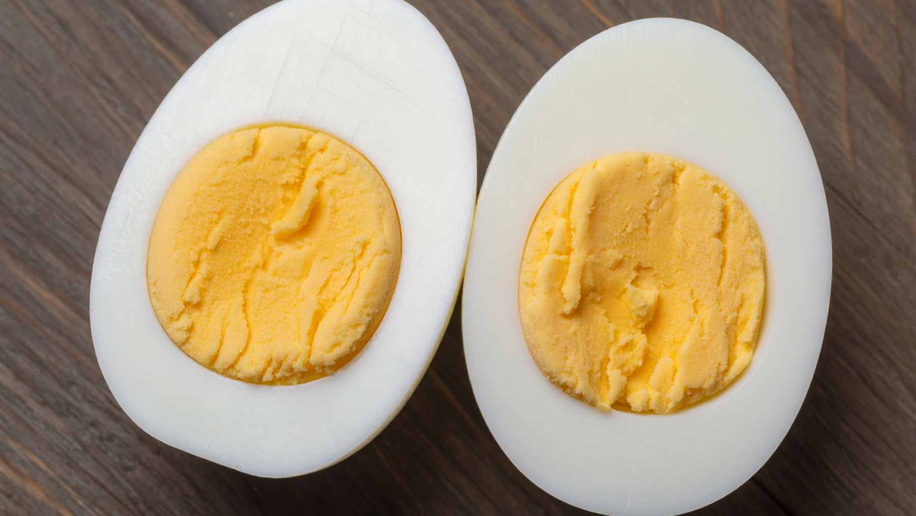 A close-up view of a perfectly cooked egg cut in half, showing a creamy, spreadable yolk and a firm white prepared using the periodic cooking method.