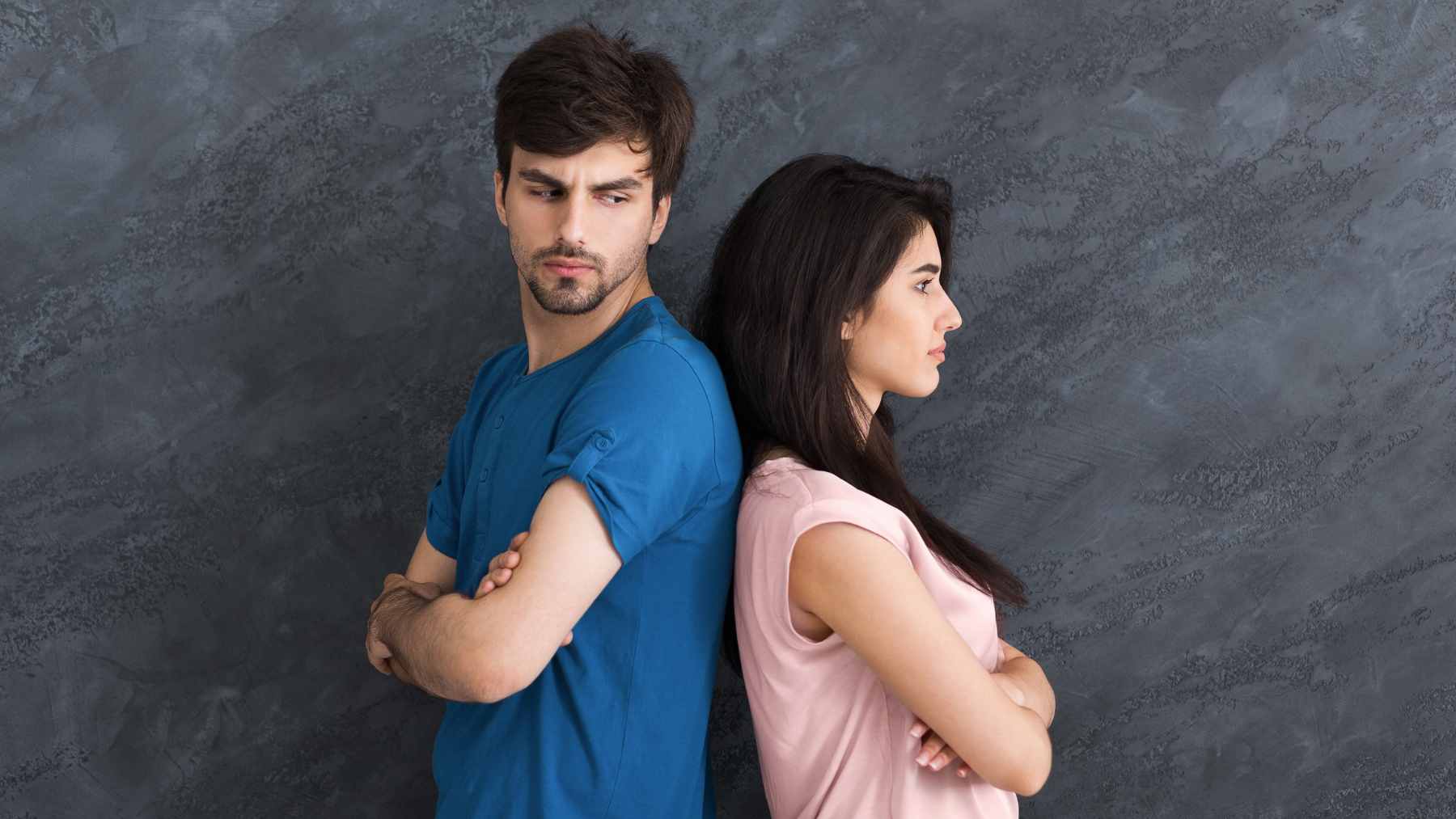 Two people sitting together looking tense and hesitant, representing the internal struggle of conflict avoidance and repressed emotion.