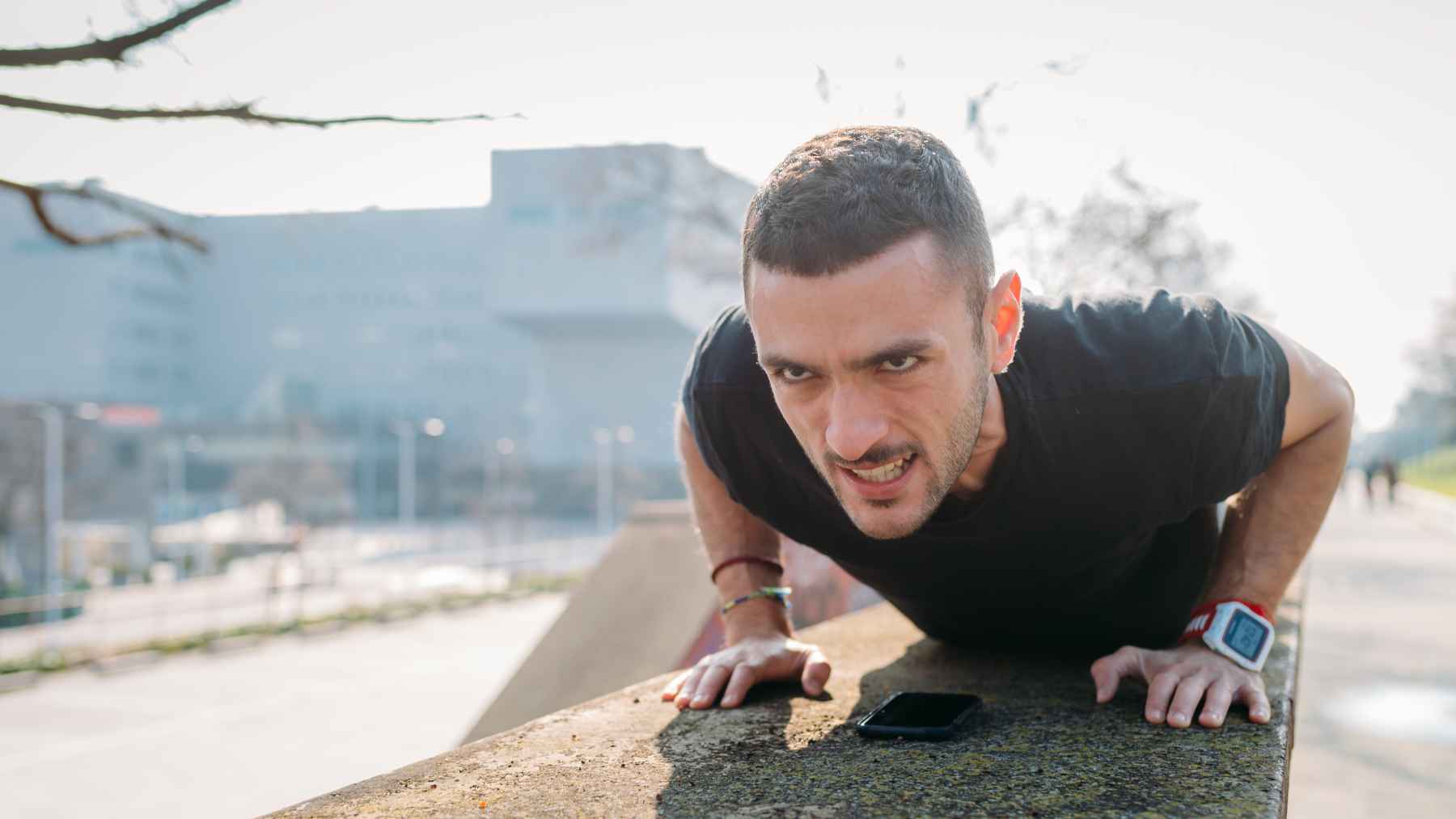 Person resting between strength training sets at the gym while recovering for the next exercise