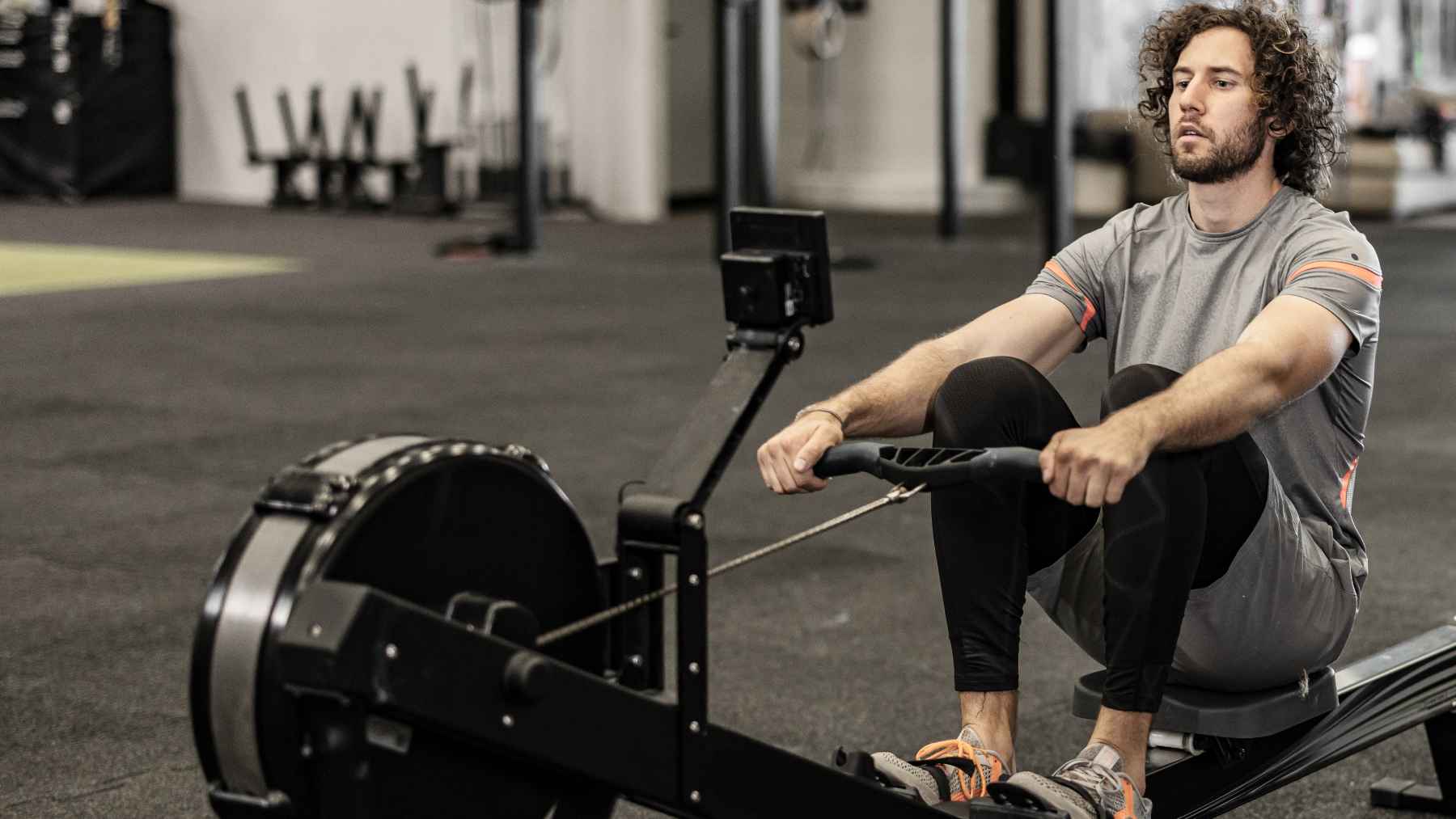 Person exercising on a rowing machine during a full-body cardio workout that improves endurance, strength, and posture.