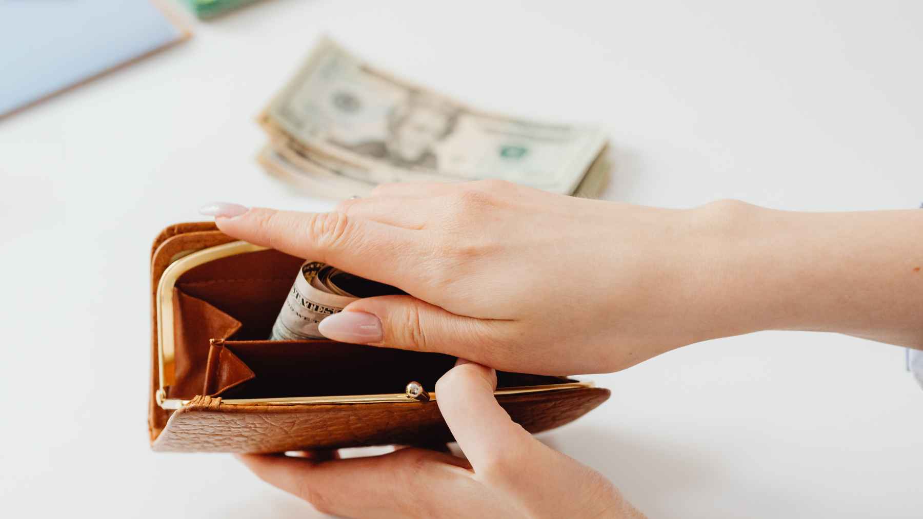 Wallet with U.S. dollar bills arranged by denomination, illustrating habits linked to organization, control, and OCD research.