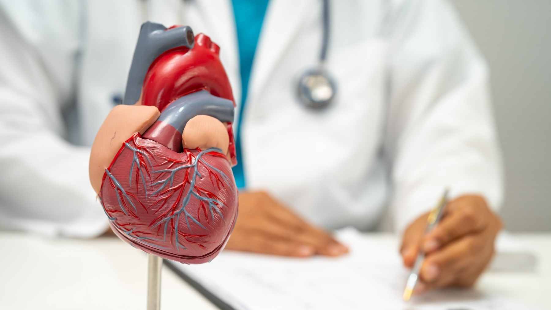 A physician reviewing cholesterol lab results and discussing long-term cardiovascular risk with a patient.