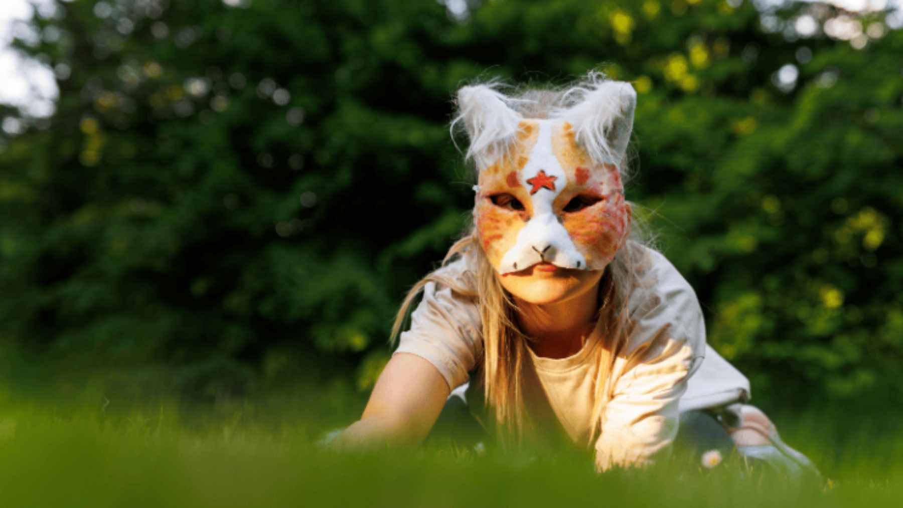 A young person wearing a decorative animal mask as part of a creative expression trend often associated with therian identity.