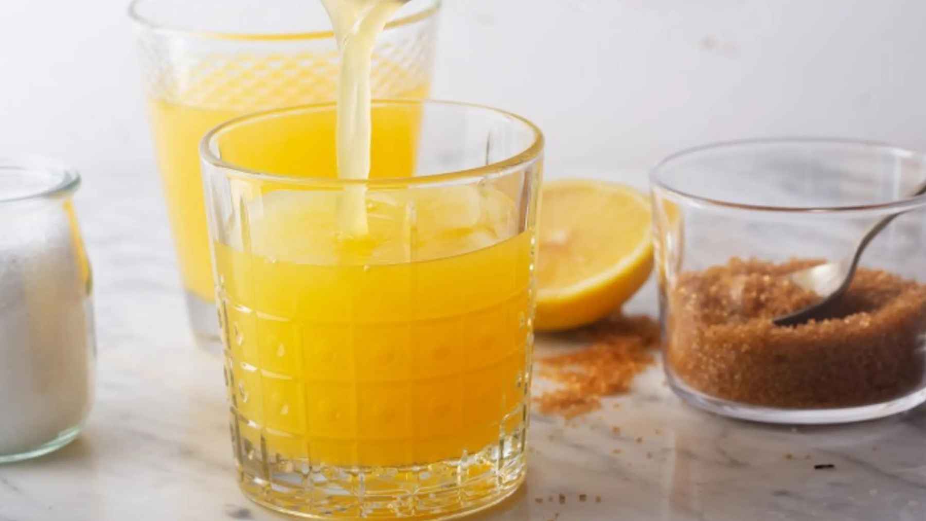 Glass of orange juice, coconut water, and salt served cold as a homemade hydration drink to help combat heat fatigue during hot weather.