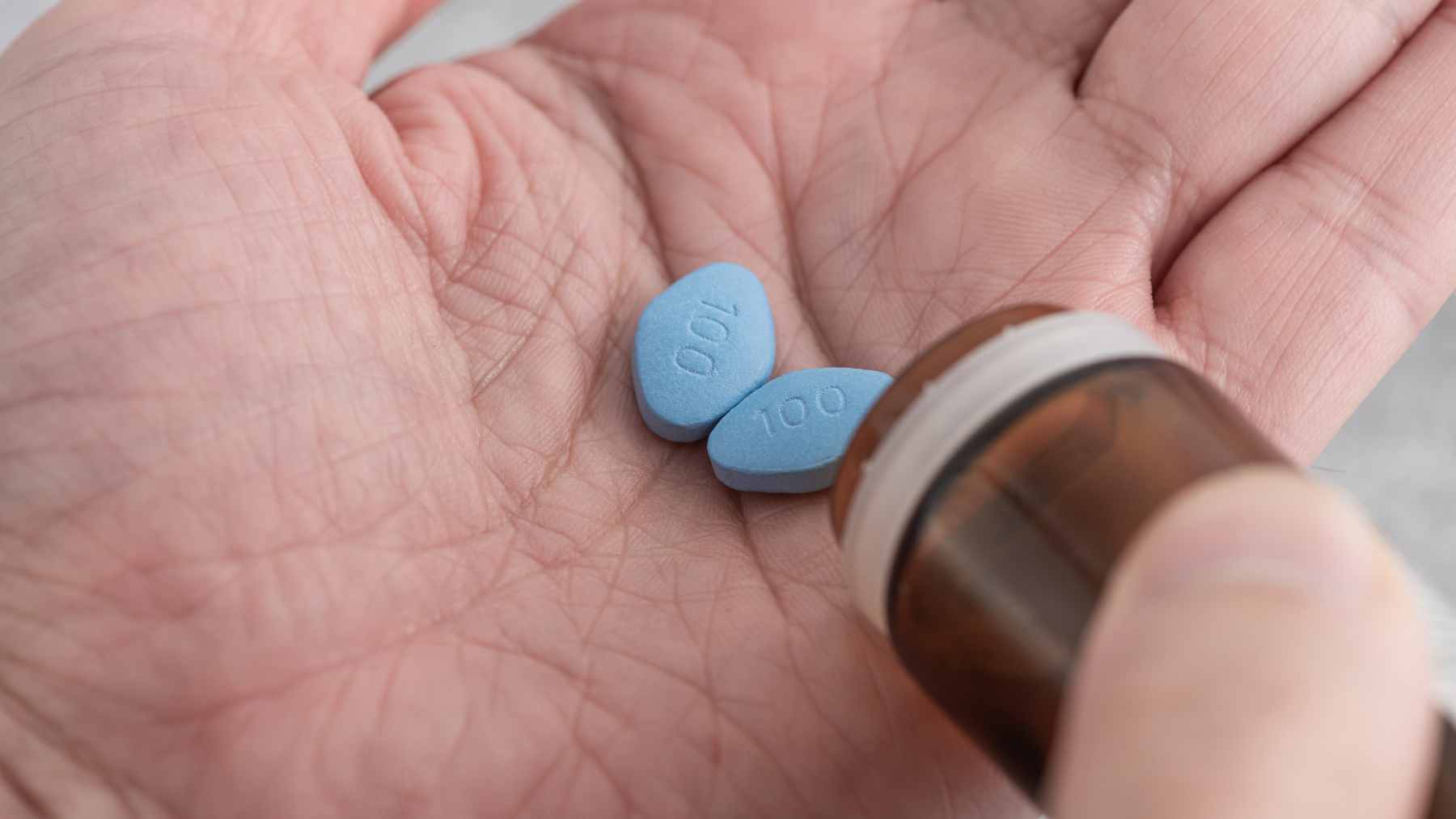 A medical concept image featuring pharmaceutical pills next to a stylized illustration of a human brain, symbolizing drug repurposing research.