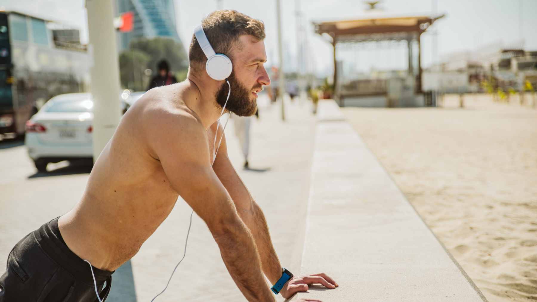 A middle-aged man cycling on a stationary bike while wearing headphones and focusing on his workout.