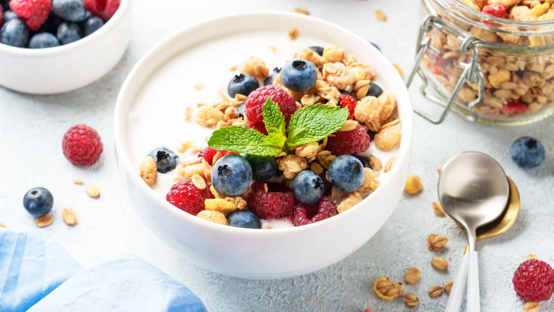 A bowl of fresh berries, yogurt, and chia seeds on a kitchen table, representing an anti-inflammatory diet.
