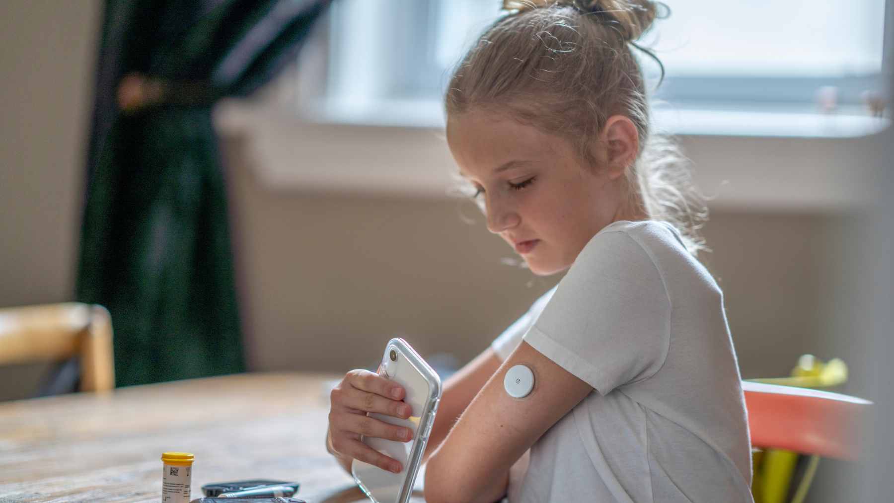 Autoimmune disease is climbing fast among children, and science says where your kids grow up may quietly tilt the odds 1 A young child sitting with a doctor during a medical checkup, representing pediatric healthcare and clinical research.