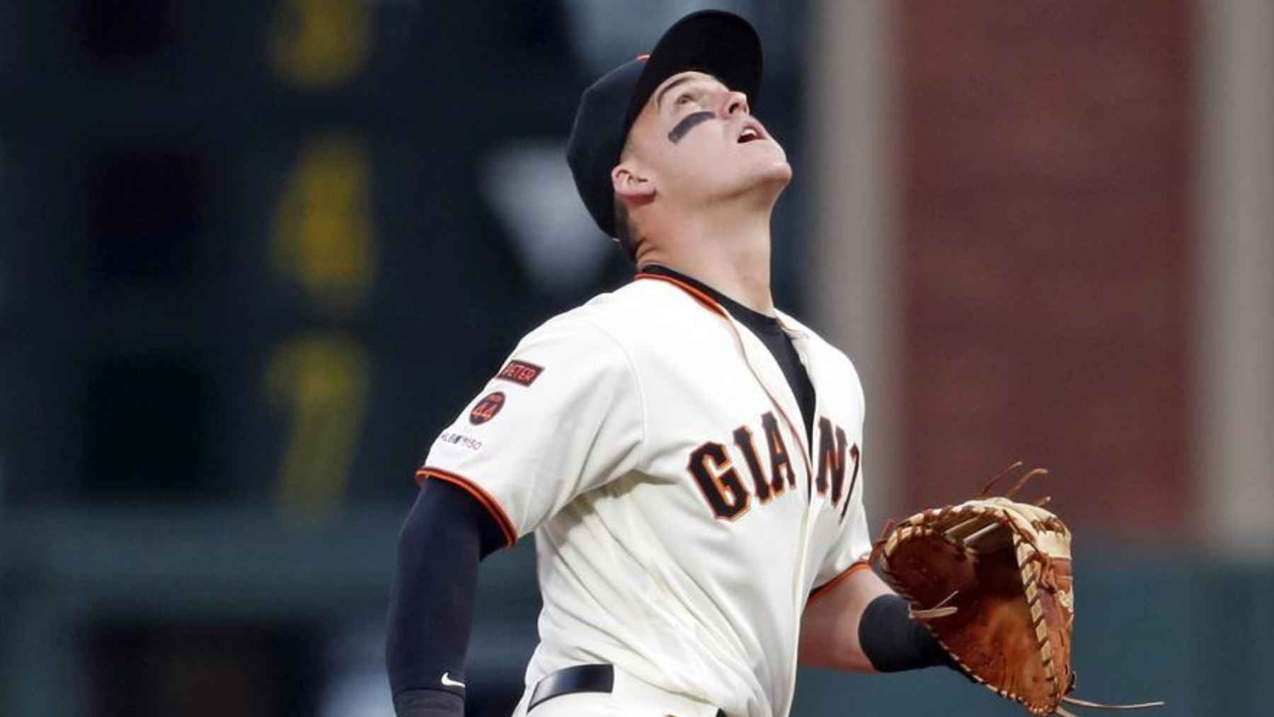 Baseball player wearing black eye paint beneath both eyes to reduce glare while tracking the ball during a game.