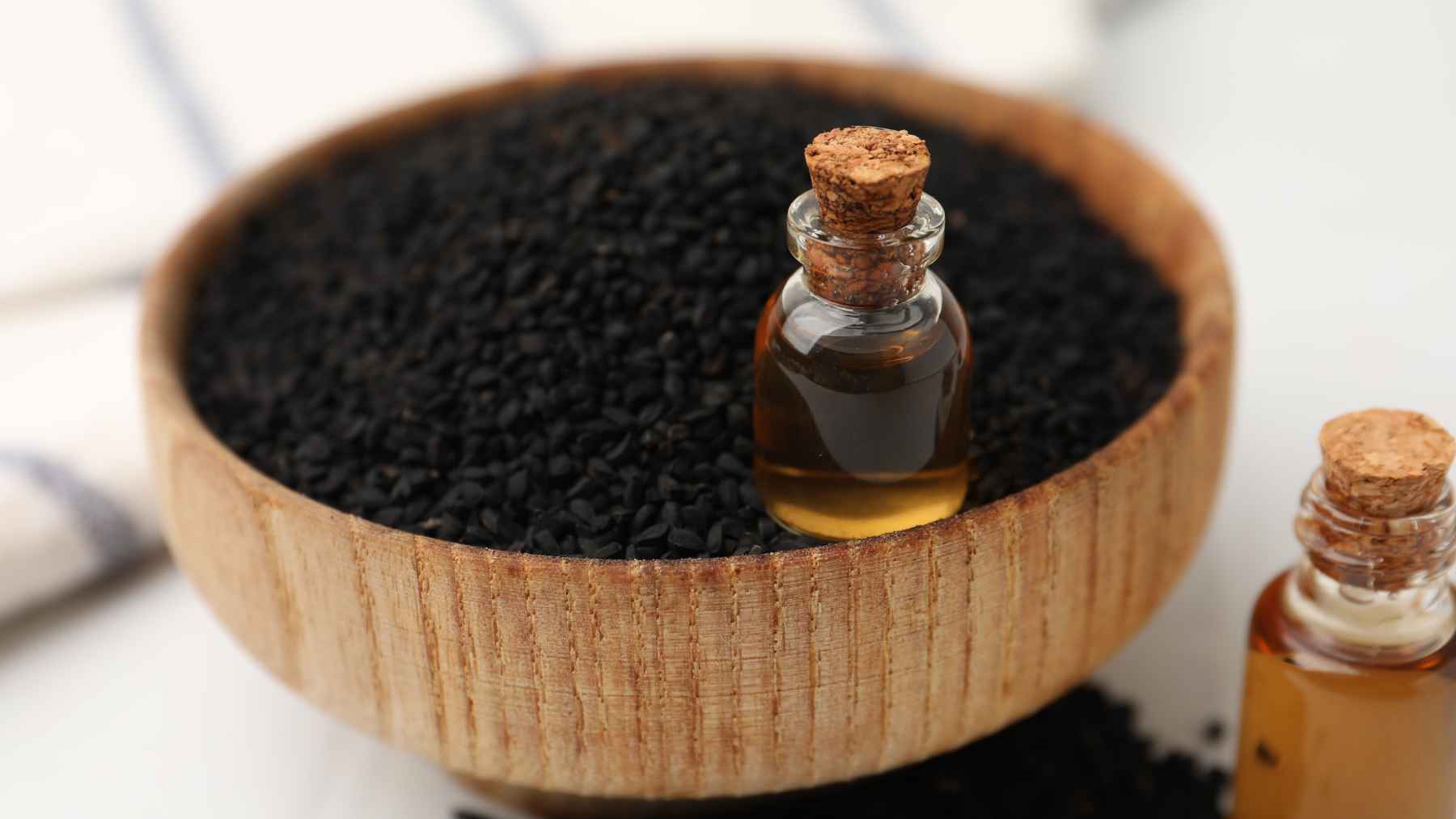 Just 5 grams of this black seed lowered bad cholesterol in eight weeks and blocked fat from building up, yet most people ignore it 1 Bowl of black cumin (Nigella sativa) seeds with bottles of black seed oil, a natural product studied for its potential effects on cholesterol and metabolic health.
