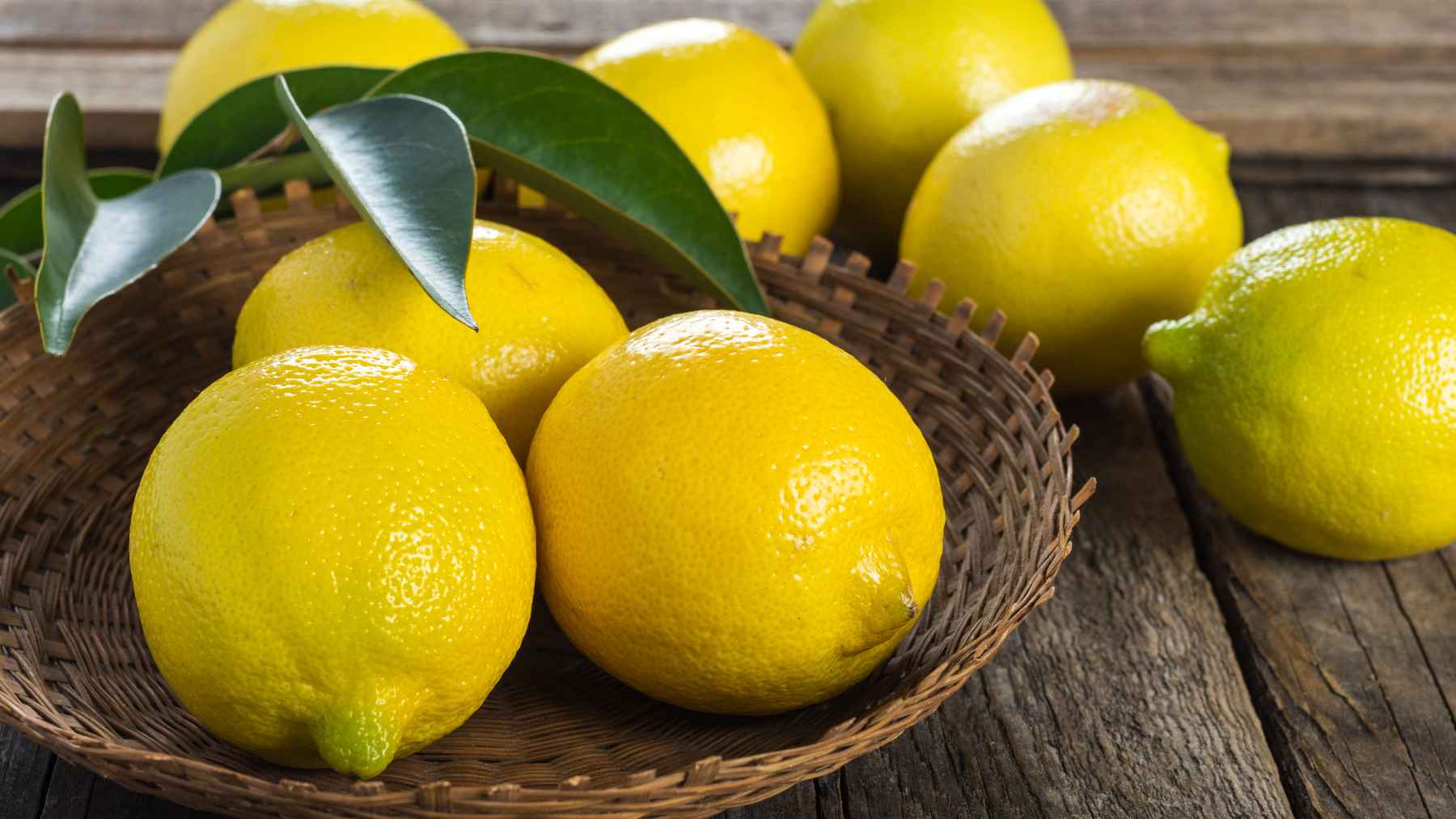 A simmering pot of fresh lemon peels, bay leaves, and water on a kitchen stove releasing fragrant steam.