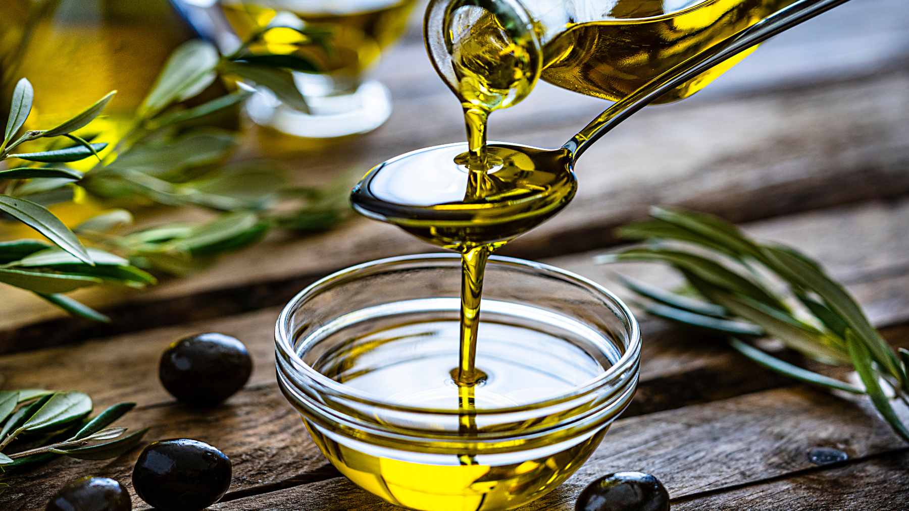 Ask a room of cardiologists what they eat to guard their own hearts, and almost all name the same everyday oil 2 A bottle of extra-virgin olive oil pouring over fresh ingredients, highlighting heart-healthy cooking fats favored by cardiologists.