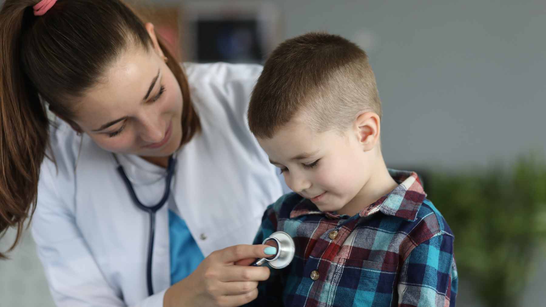 A young child sitting with a doctor during a medical checkup, representing pediatric healthcare and clinical research.