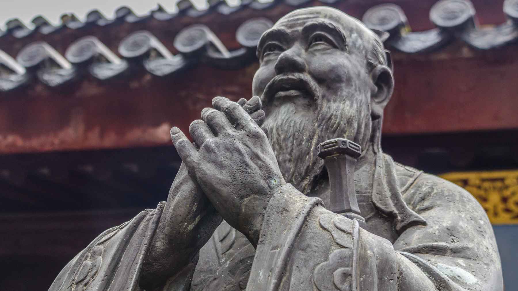 Confucius, Chinese philosopher: "I buy rice to live and flowers to have something to live for," and the lesson about your needs runs deep 1 Statue of Confucius at a traditional Chinese temple, representing the philosopher’s teachings on balancing life’s essential needs with purpose and fulfillment.