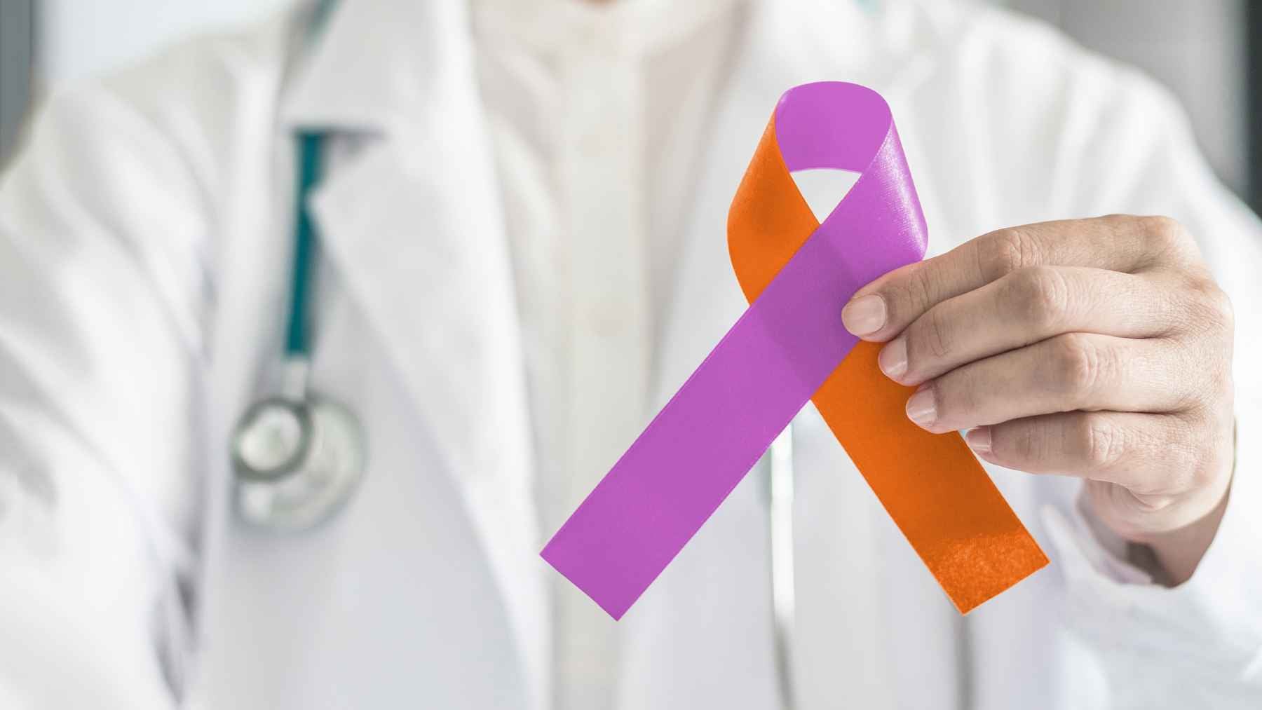 A medical professional discussing health symptoms and early cancer warnings with a patient in a clinic.