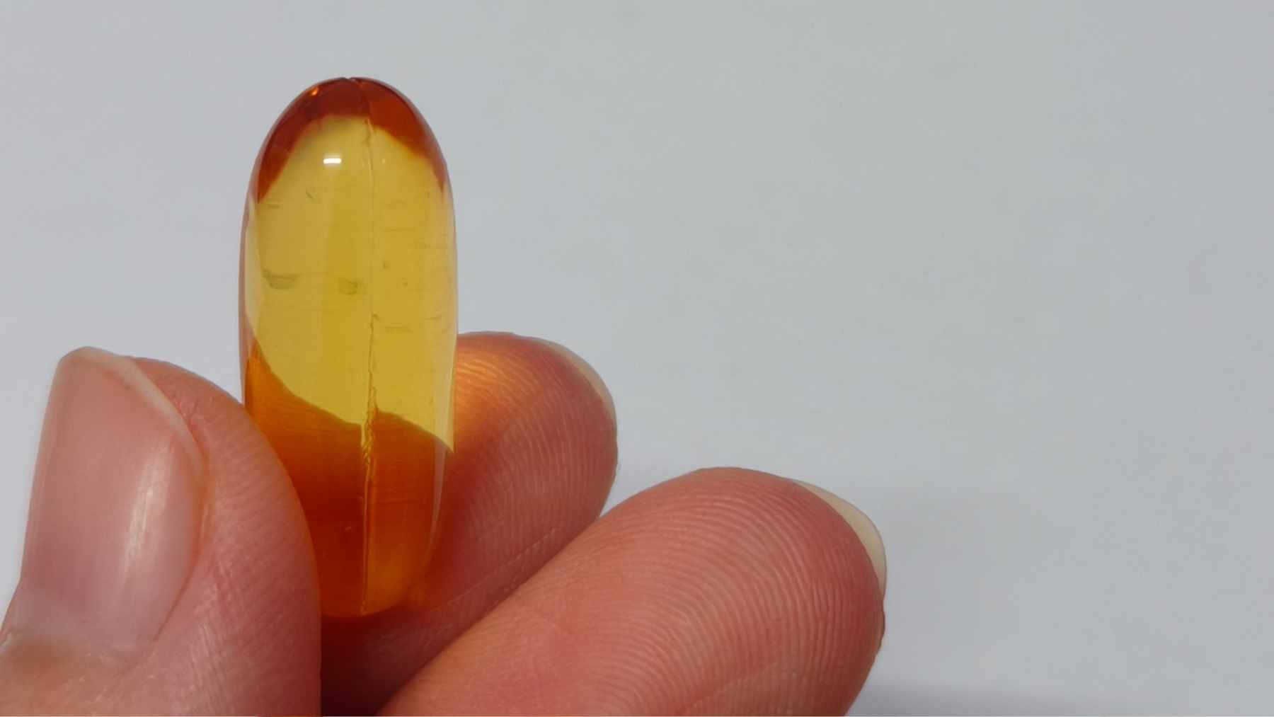 It's not the fish oil pill that protects you from dementia–a new study reveals the one thing that actually matters for your brain 1 Close-up of a fish oil supplement capsule next to a plate of fresh salmon, symbolizing the difference between isolated nutrients and whole foods for brain health.