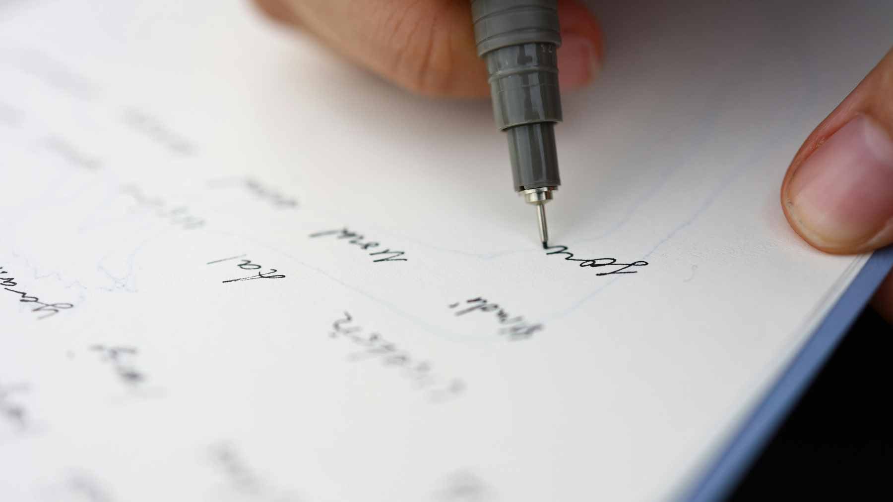 An older adult using a digital pen on a tablet to perform handwriting-based cognitive screening tasks.