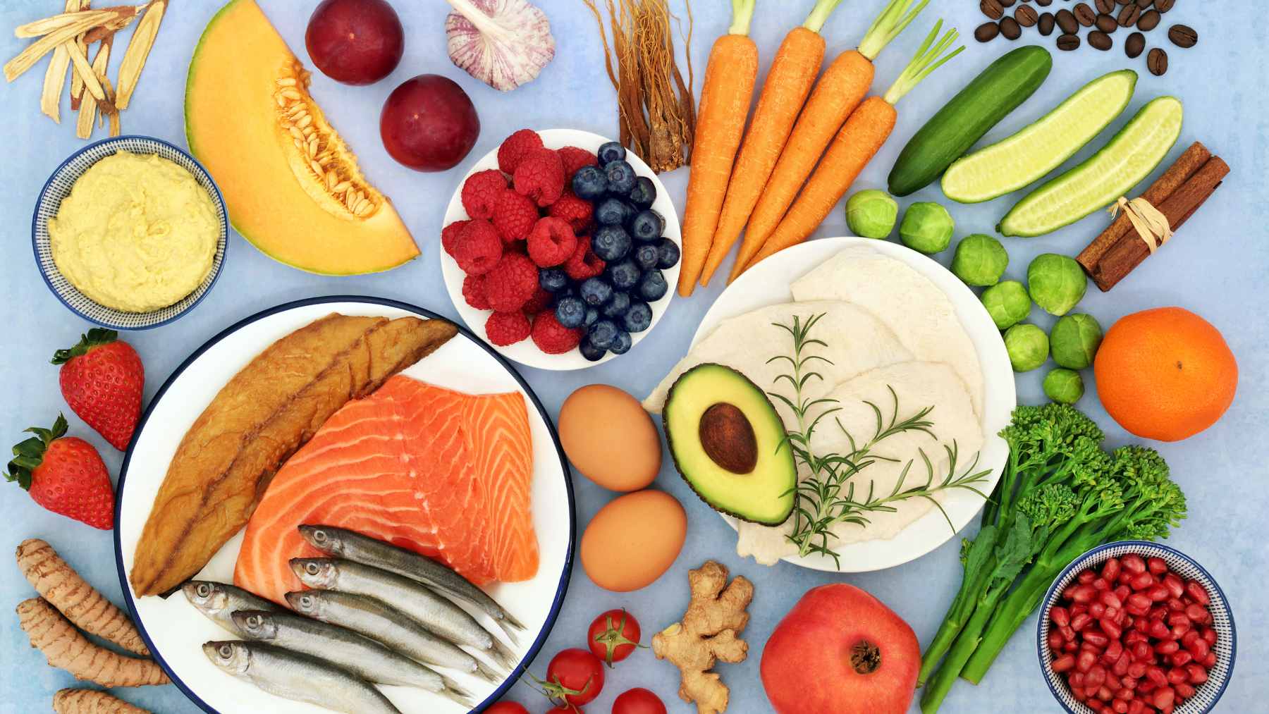 A vibrant selection of heart-healthy foods including salmon, oats, berries, lentils, and avocados arranged on a table.