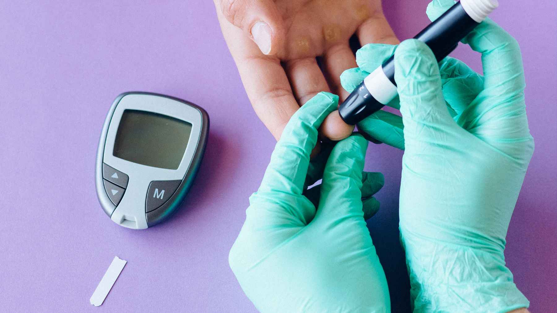 A common diabetes drug may slow the age-related vision loss that steals sight from millions, though that's not why doctors first prescribed it 1 Healthcare professional performing a blood glucose test on a patient, illustrating diabetes management and research on metformin's potential role in reducing age-related macular degeneration risk.