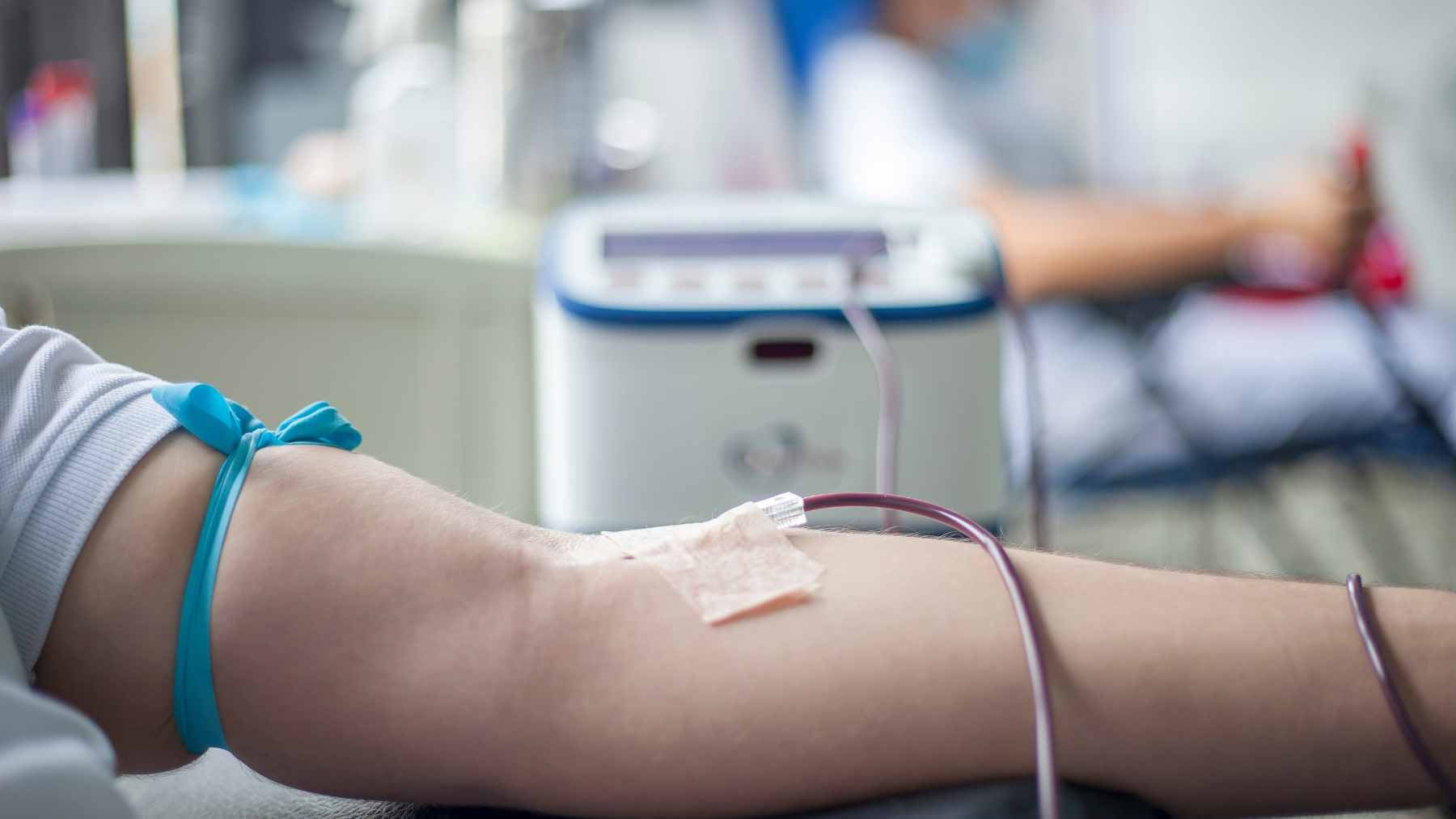 A medical professional preparing a blood plasma unit in a hospital laboratory for a patient transfusion procedure.