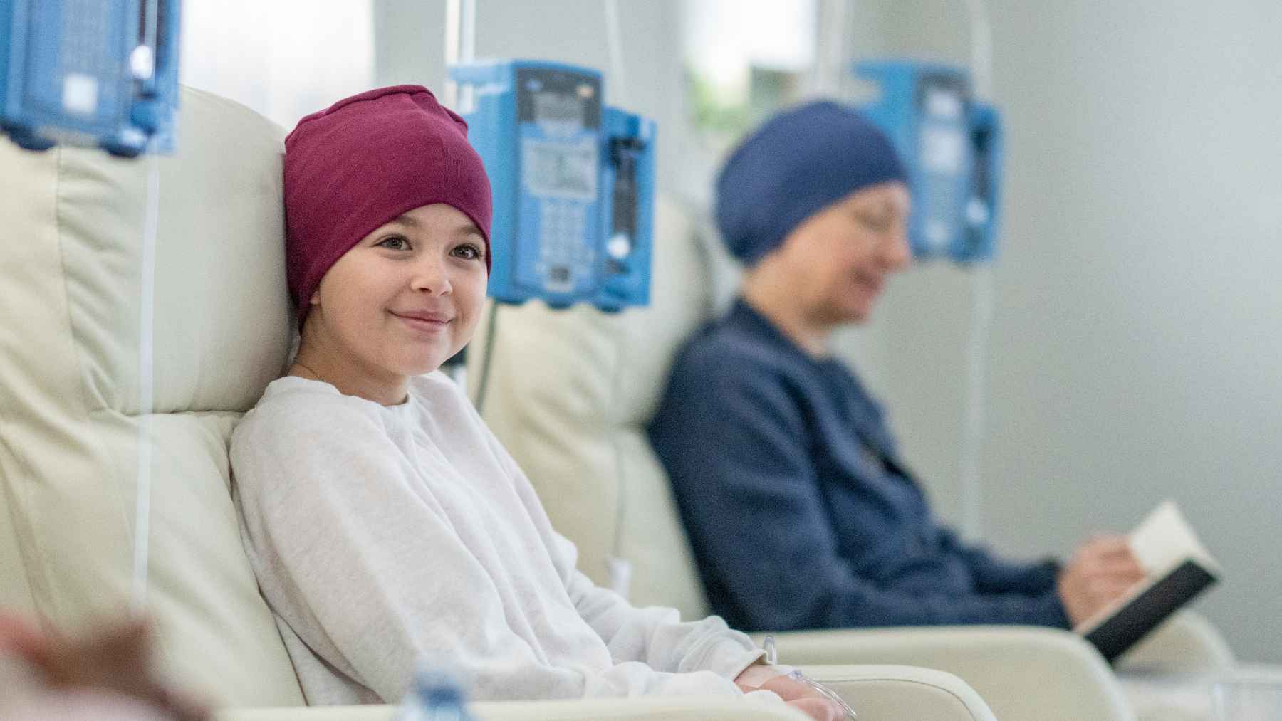 A pediatric oncologist speaks with a child and family during a hospital visit for cancer treatment and supportive care.