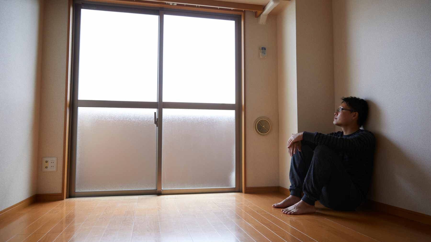 An older adult sitting alone at a table reflecting, symbolizing the realization of one-sided friendships during the aging process.