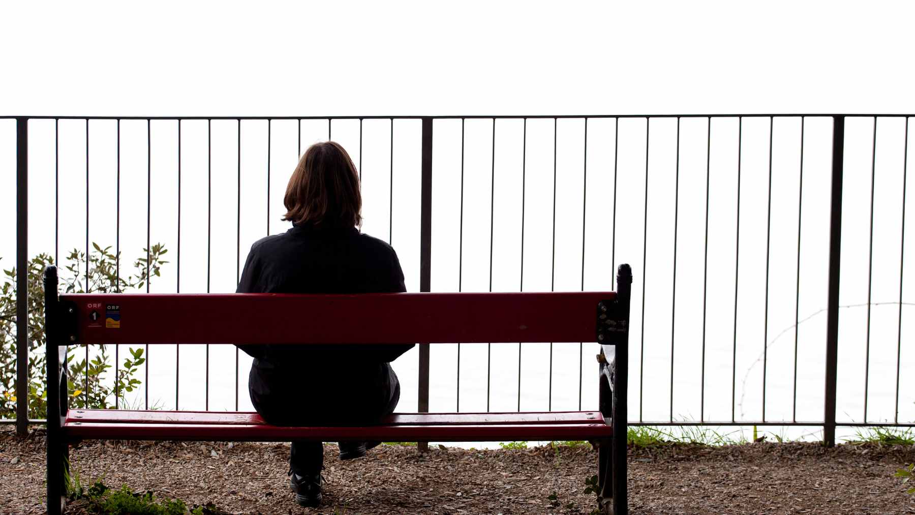 An older adult sitting alone at a table reflecting, symbolizing the realization of one-sided friendships during the aging process.