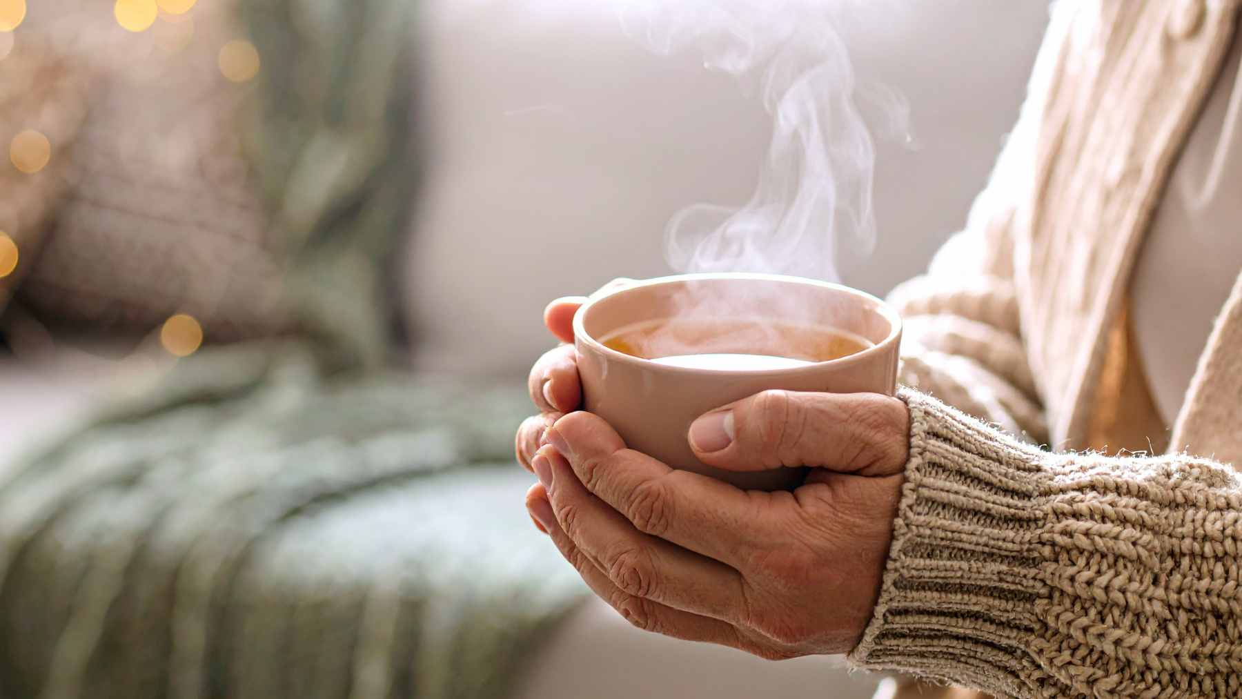 A steaming mug of herbal tea with honey and lemon slices placed on a wooden table, representing natural comfort for respiratory relief.
