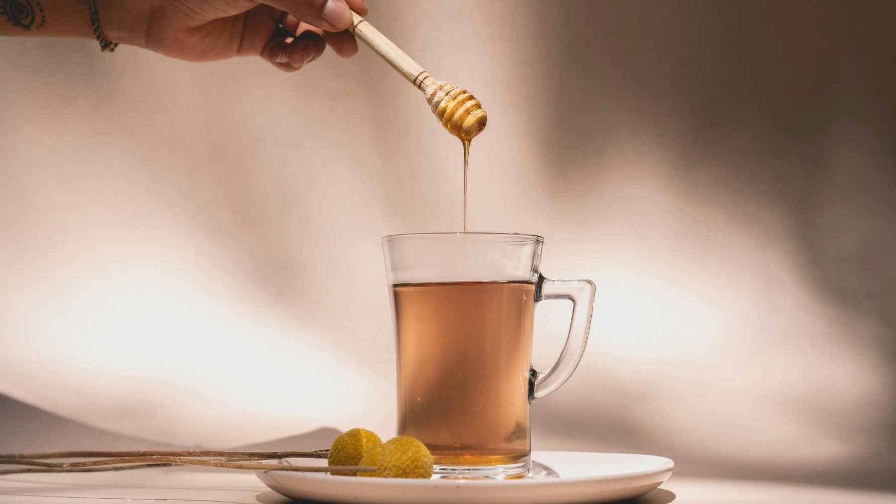 No drink can kill the flu virus, but these six teas could ease your cough, sore throat, and runny nose faster than you'd expect 1 A steaming mug of herbal tea with honey and lemon slices placed on a wooden table, representing natural comfort for respiratory relief.