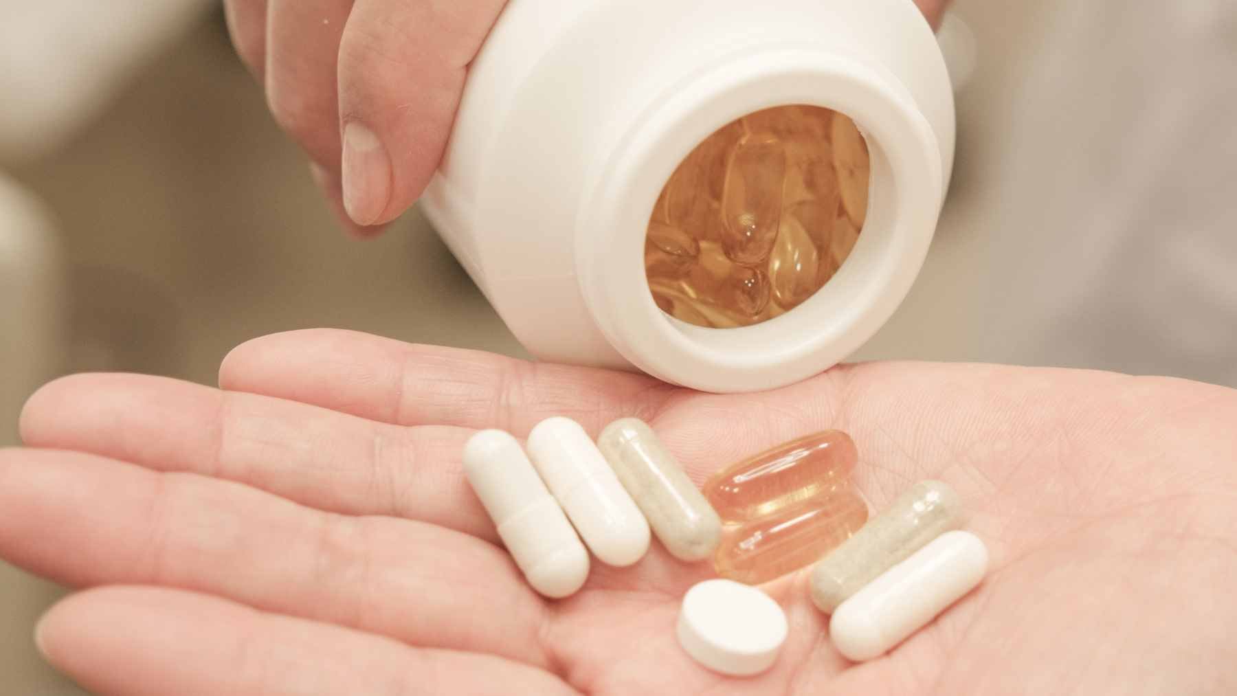 A close-up of various vitamin D supplement bottles placed next to a medical blood test report, symbolizing the importance of laboratory verification.