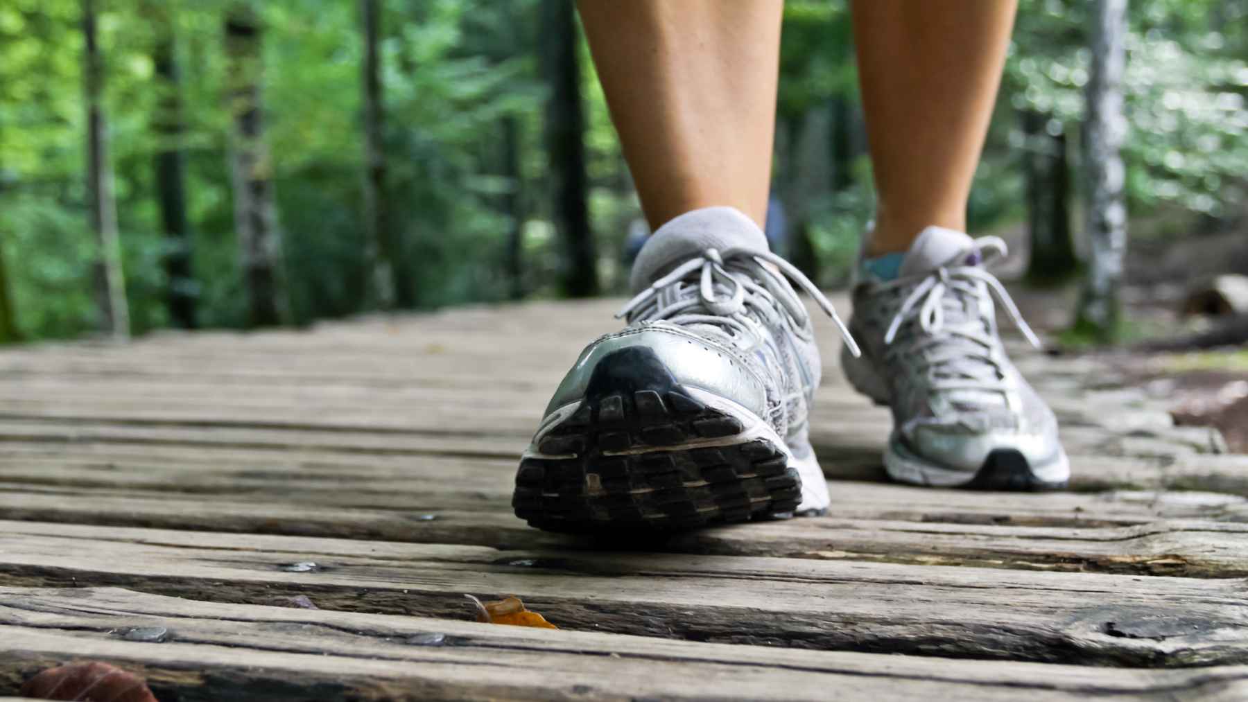 An older adult taking a healthy daily walk in a park, representing exercise benefits for cognitive health.