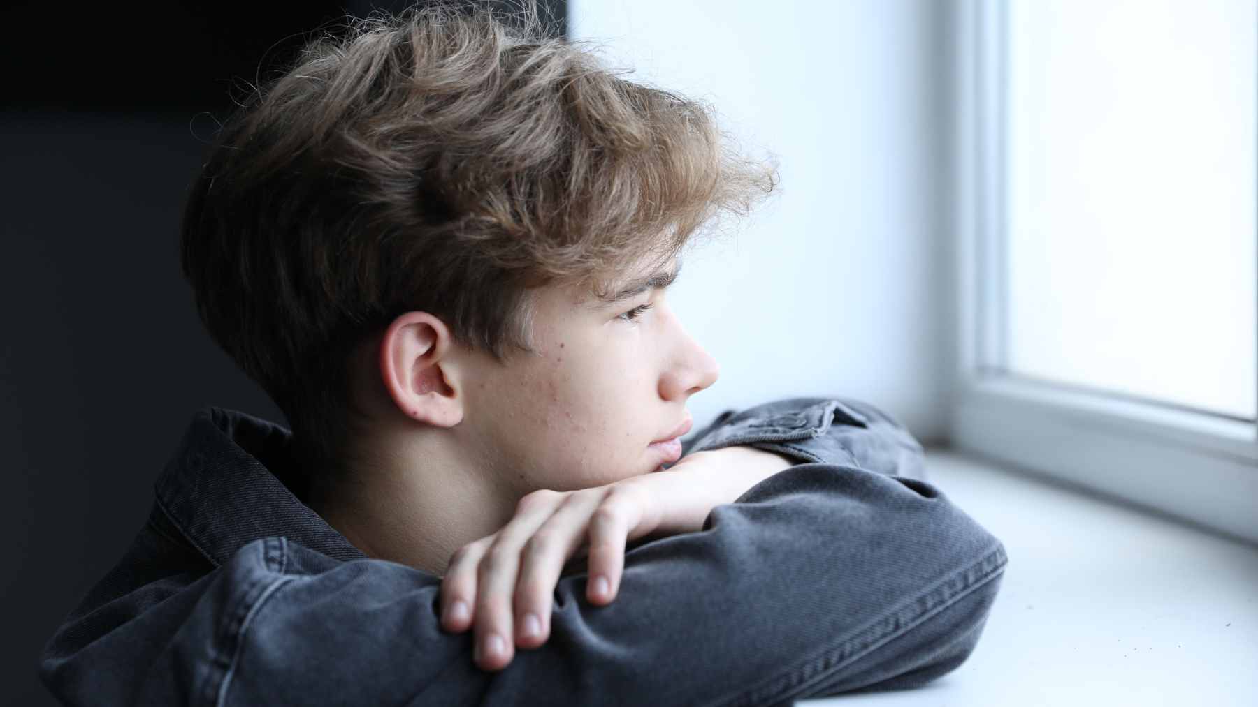 A medical professional discussing mental health treatment options with a teenager in a clinical setting.