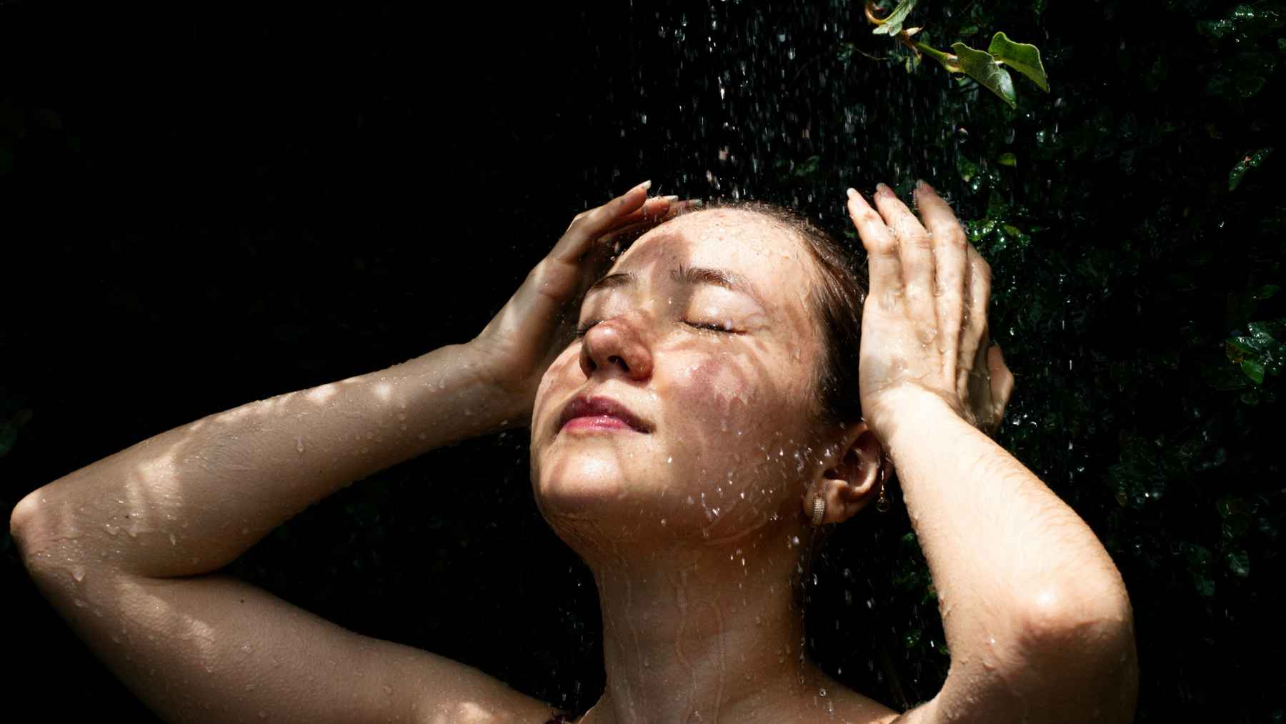 Person using cold water to cool the head and neck during hot weather