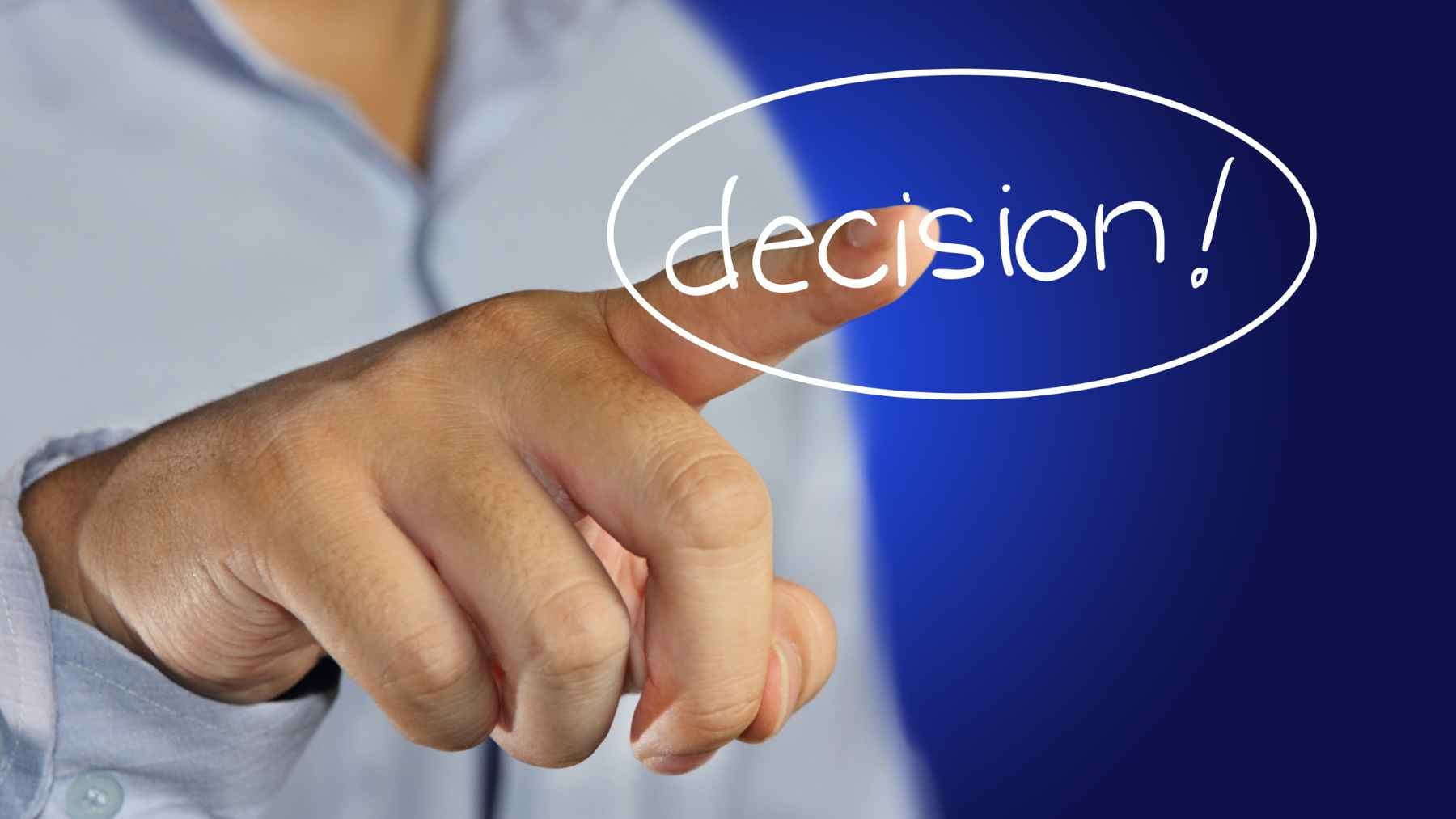 Person pointing at the word “decision” in a graphic about making choices