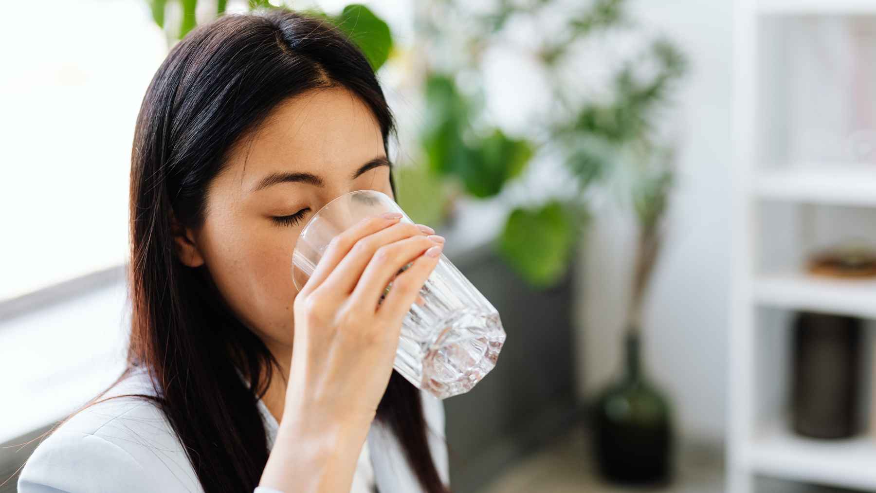 Person drinking a glass of water to stay hydrated during high blood sugar as part of daily diabetes management.