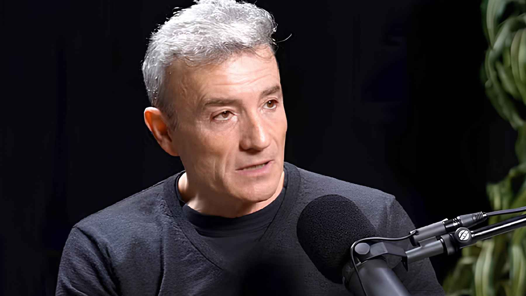 Man speaking into a microphone during an interview about exercise, aging, and physical strength