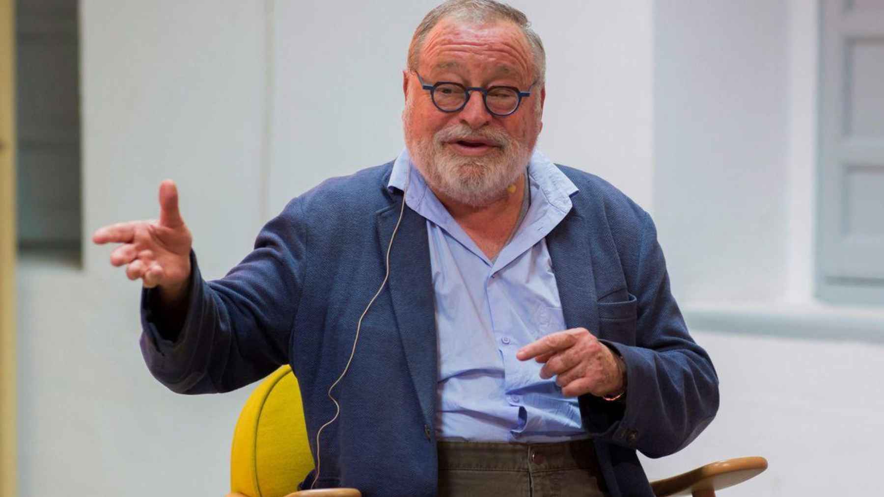 Fernando Savater speaking at an event, reflecting on wealth, money, freedom and the idea that financial security can make a simpler life possible