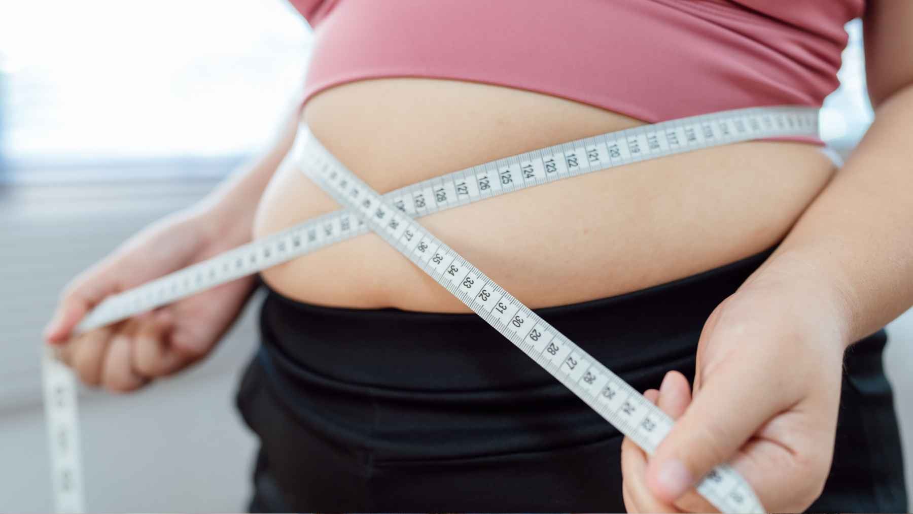 A medical checkup measuring waist circumference and assessing metabolic health risks like belly fat and diabetes.