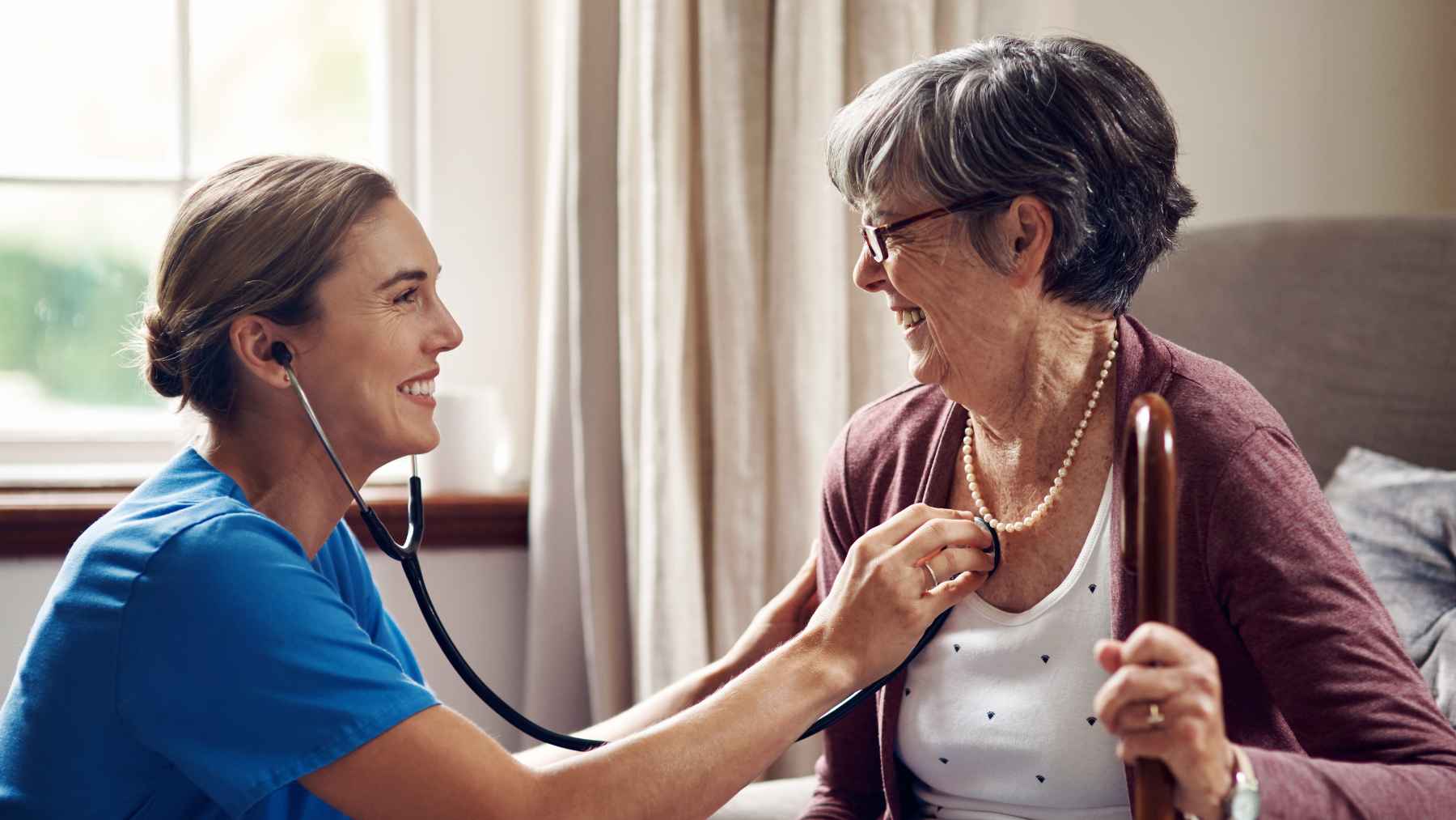 Healthcare professional listening to an older woman's heart during a routine cardiovascular checkup.