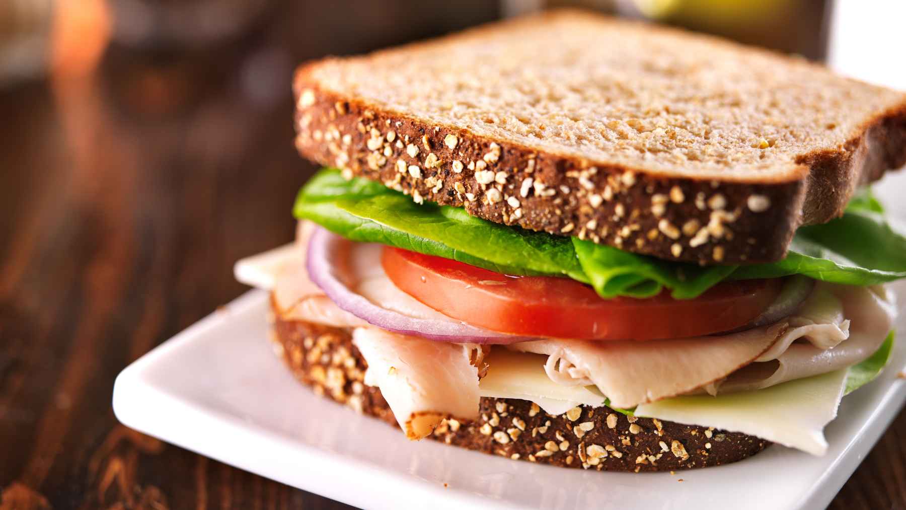 A fresh high-protein tomato sandwich prepared with whipped cottage cheese on whole-wheat bread.